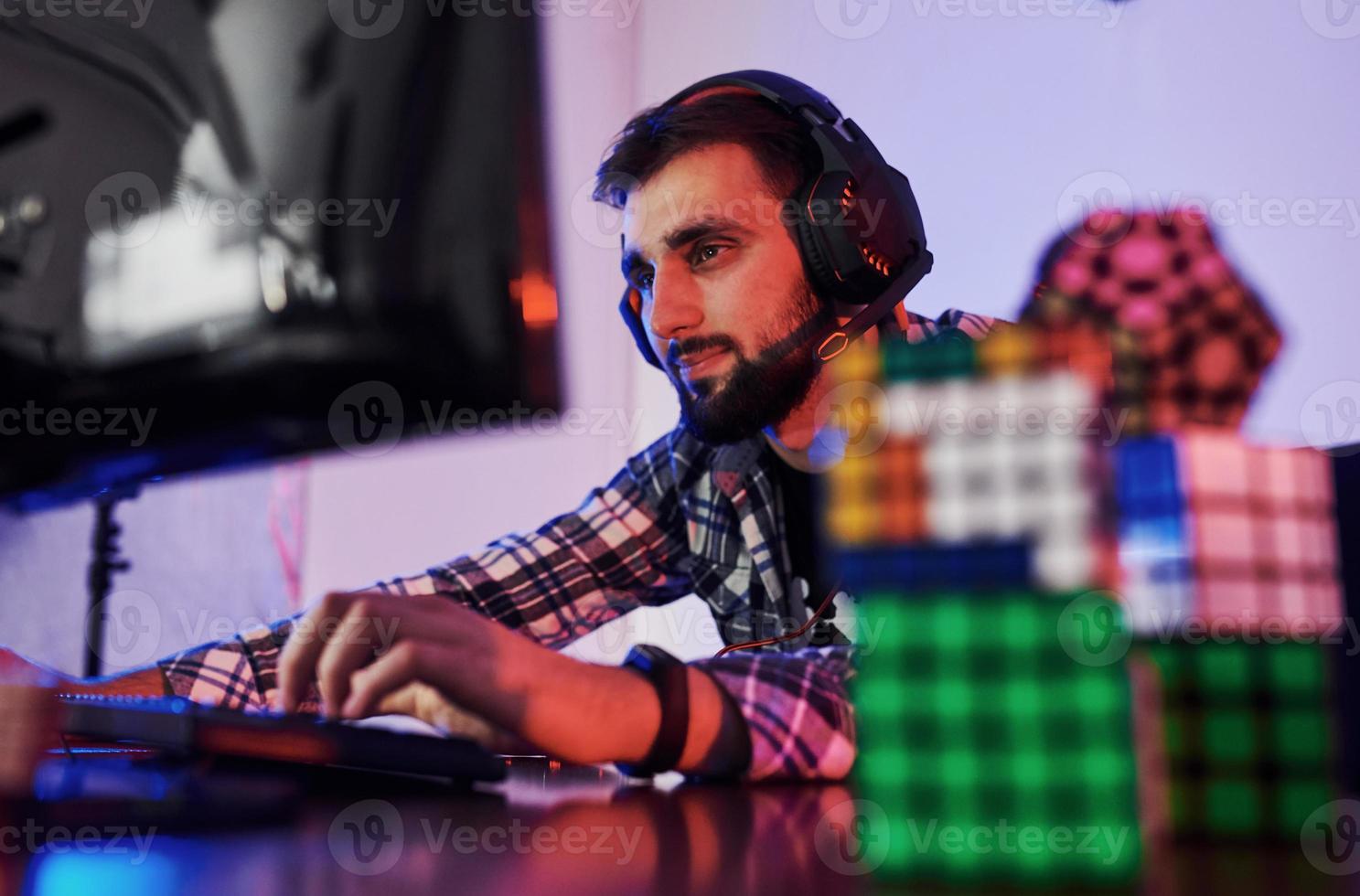 Portrait of young bearded pro gamer playing in online video game photo