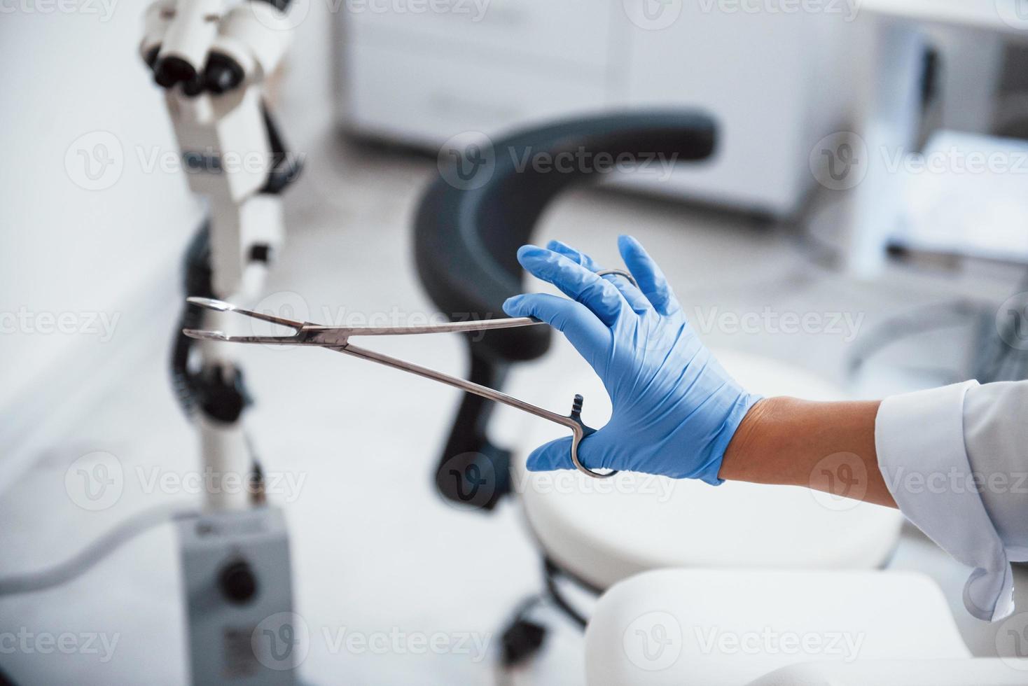 Close up view of female doctor hands that holds forceps photo