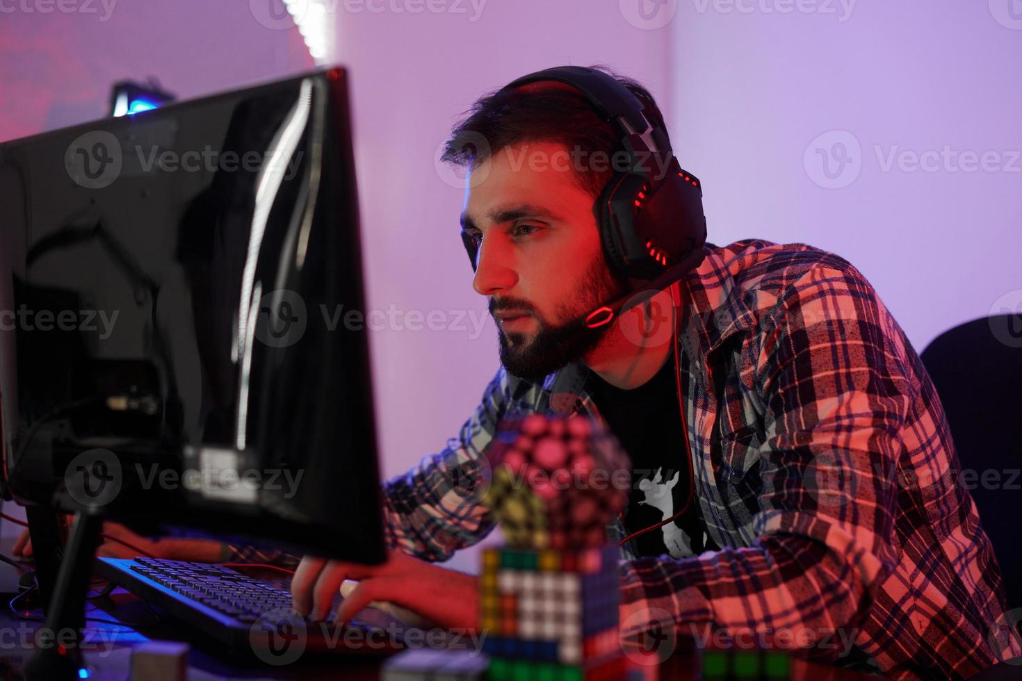 Portrait of young bearded pro gamer playing in online video game photo