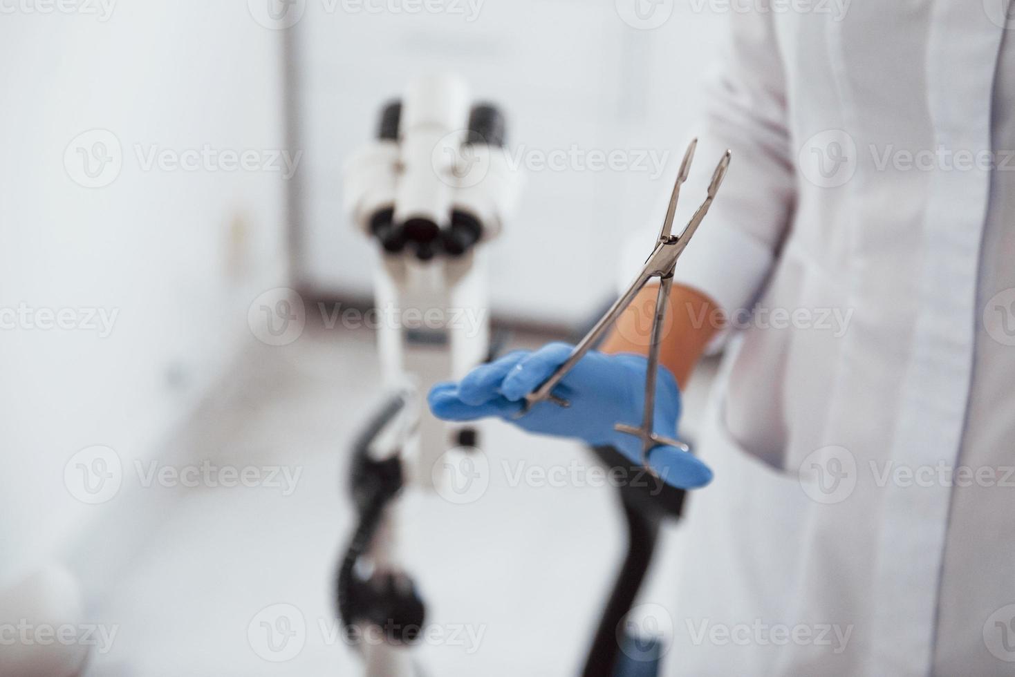 Close up view of female doctor hands that holds forceps photo