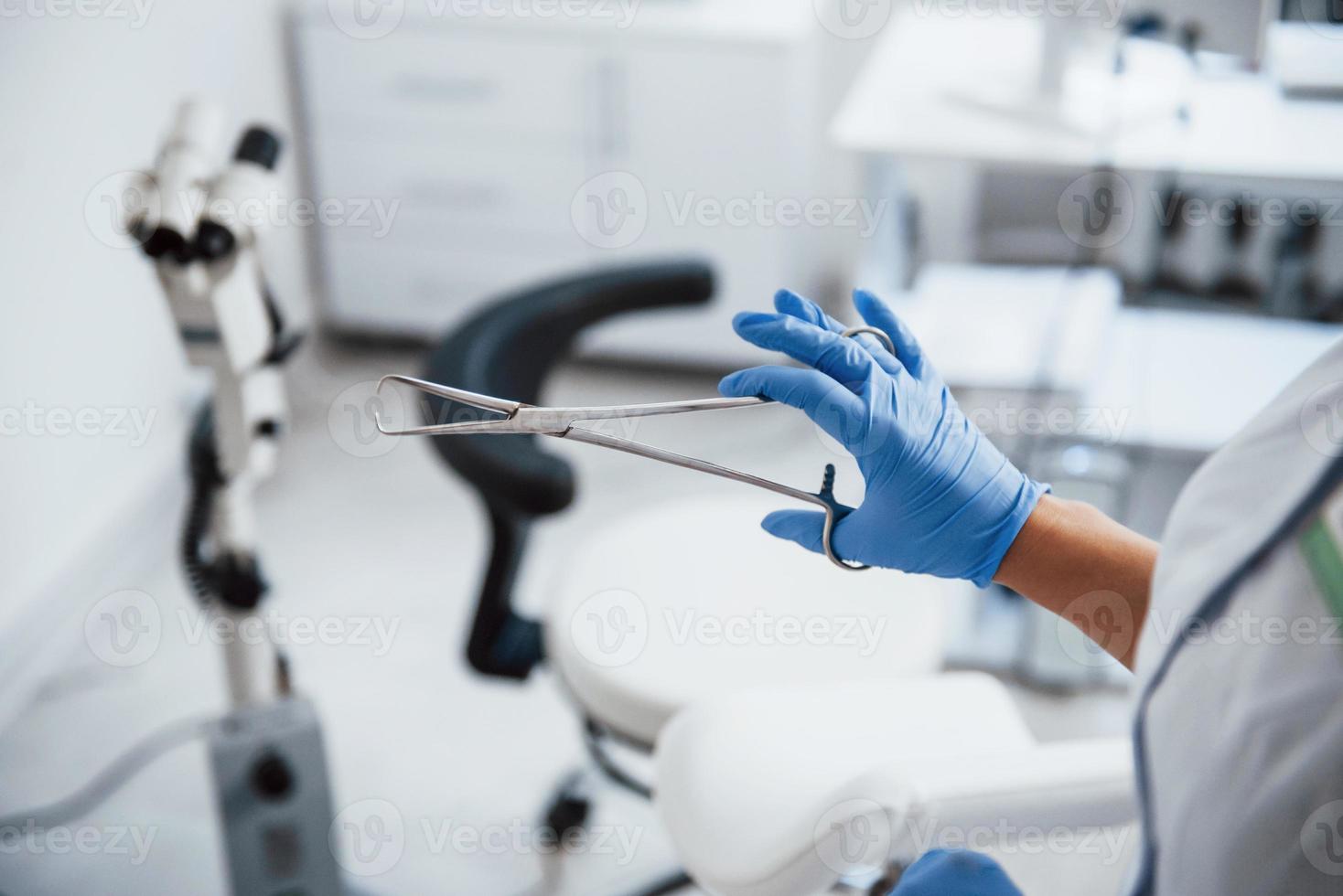 Close up view of female doctor hands that holds forceps photo
