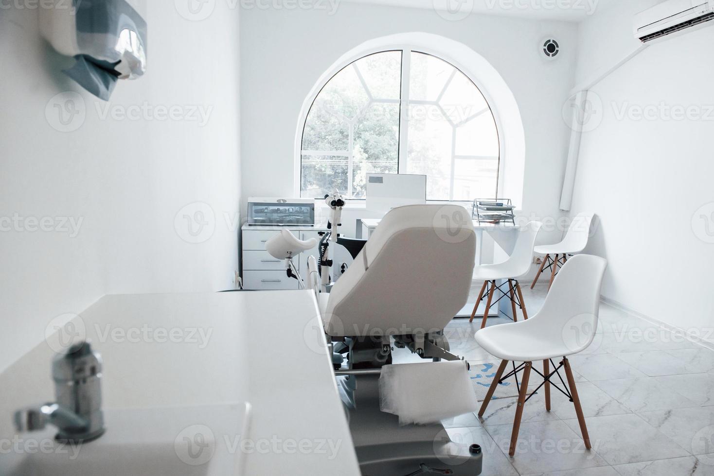 Interior of obstetric clinic cabinet indoors with computer and bed photo