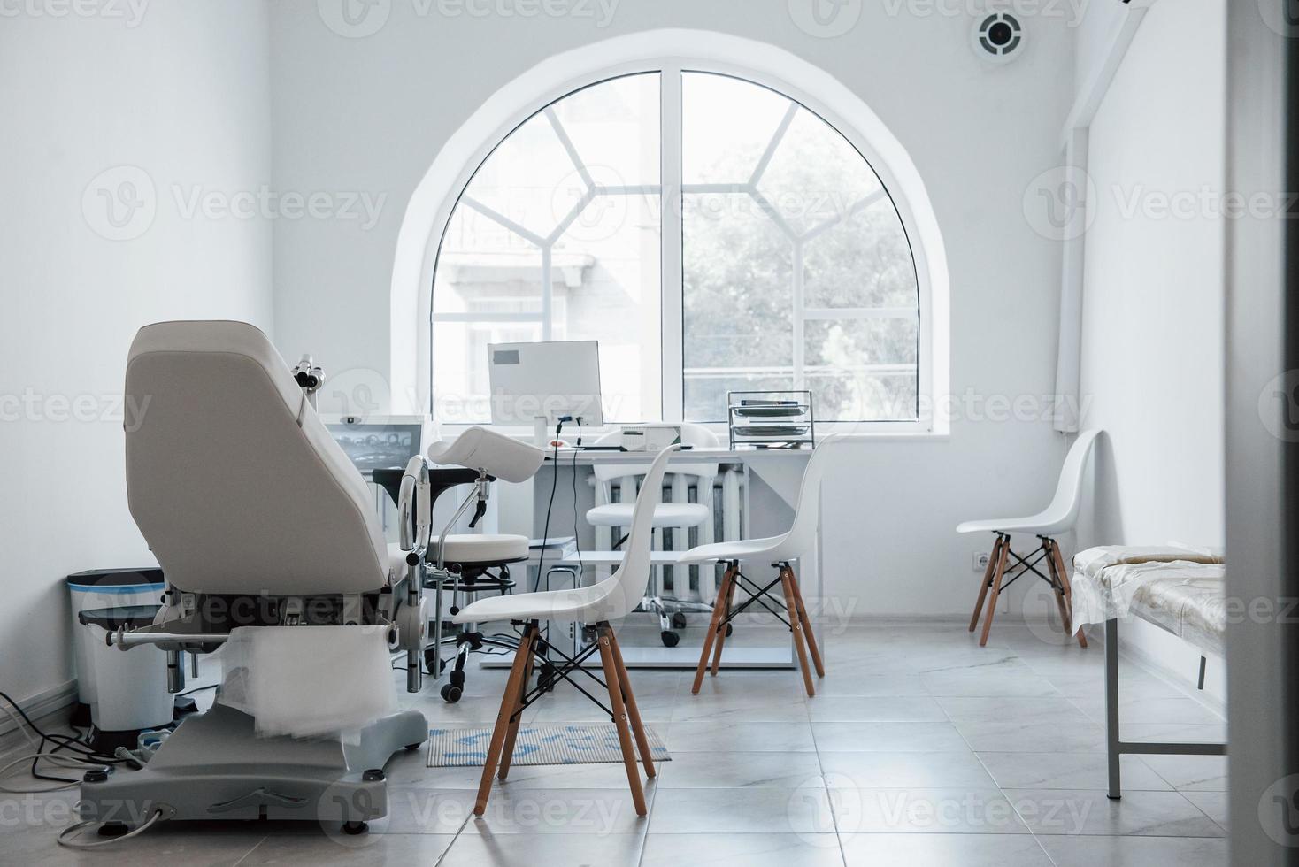 Interior of obstetric clinic cabinet indoors with computer and bed photo