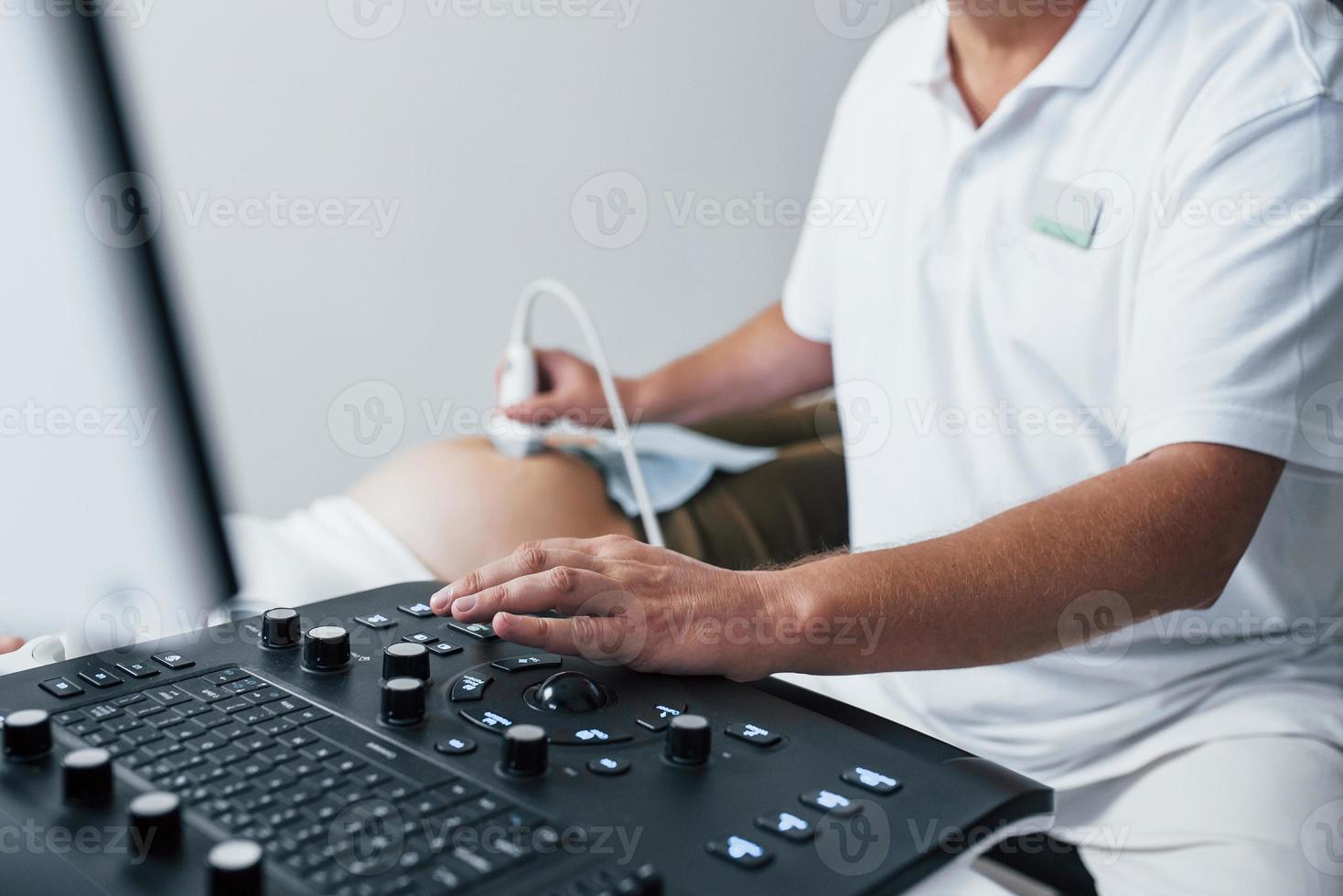 Male doctor does ultrasound for a pregnant woman in the hospital photo