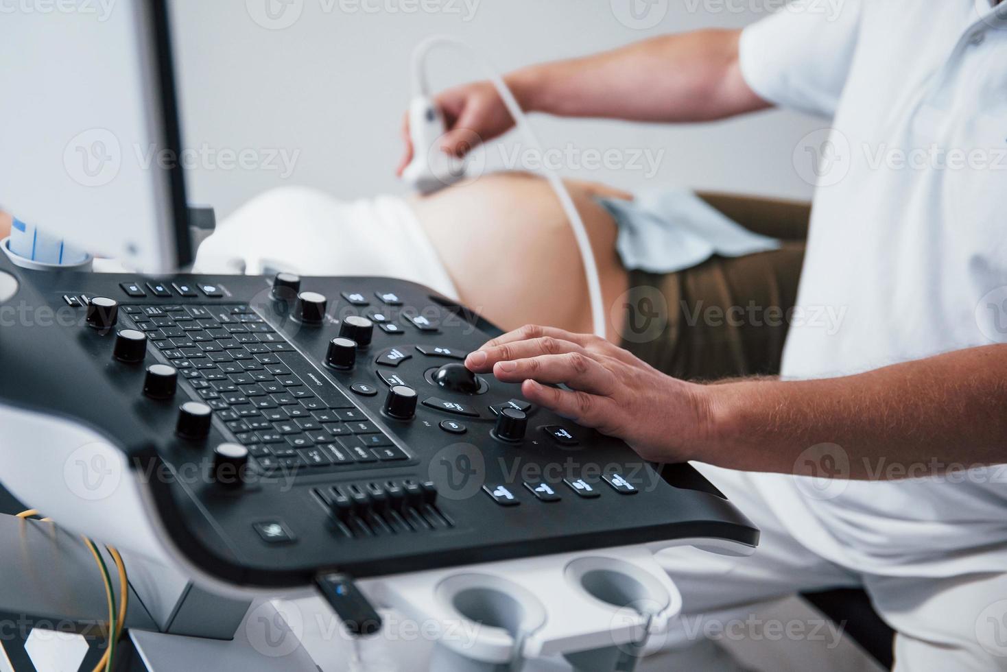 Male doctor does ultrasound for a pregnant woman in the hospital photo