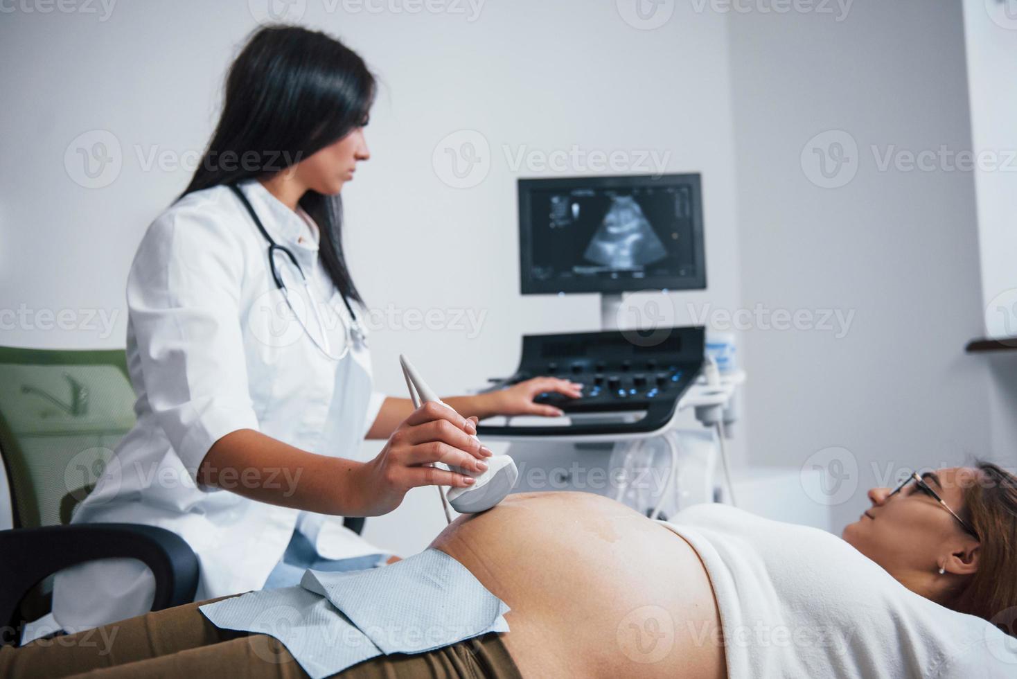 Female doctor does ultrasound for a pregnant woman in the hospital photo