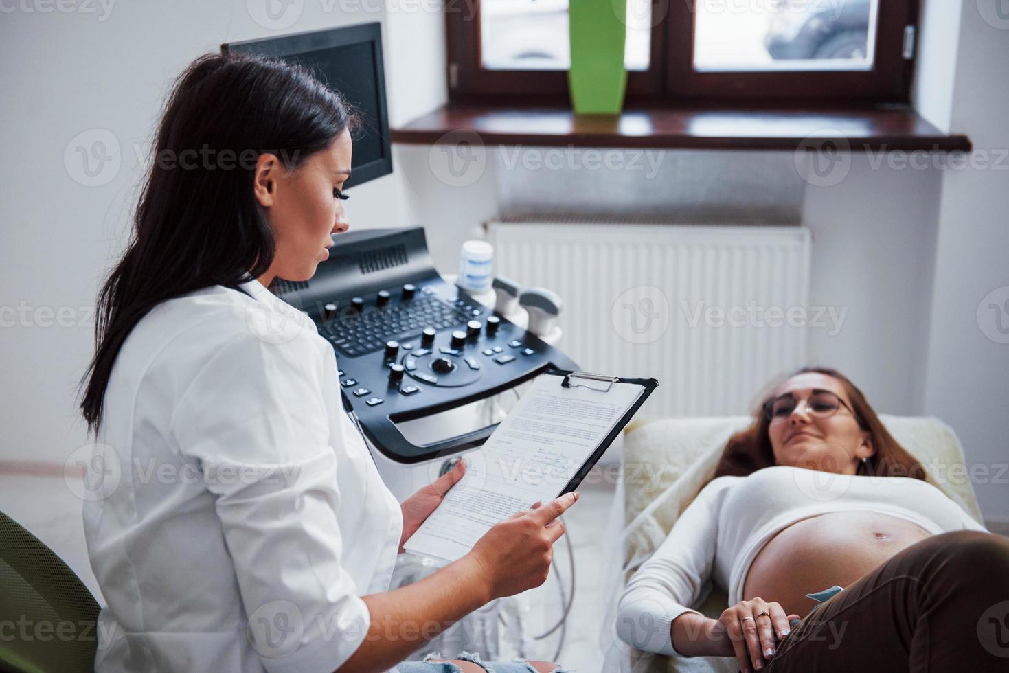 doctora habla sobre los resultados de la ecografía para una mujer embarazada en el hospital foto