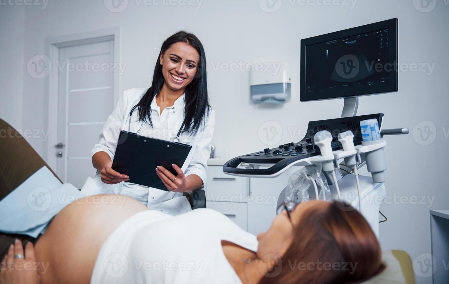 Female doctor talks about results of ultrasound for a pregnant woman in the hospital photo