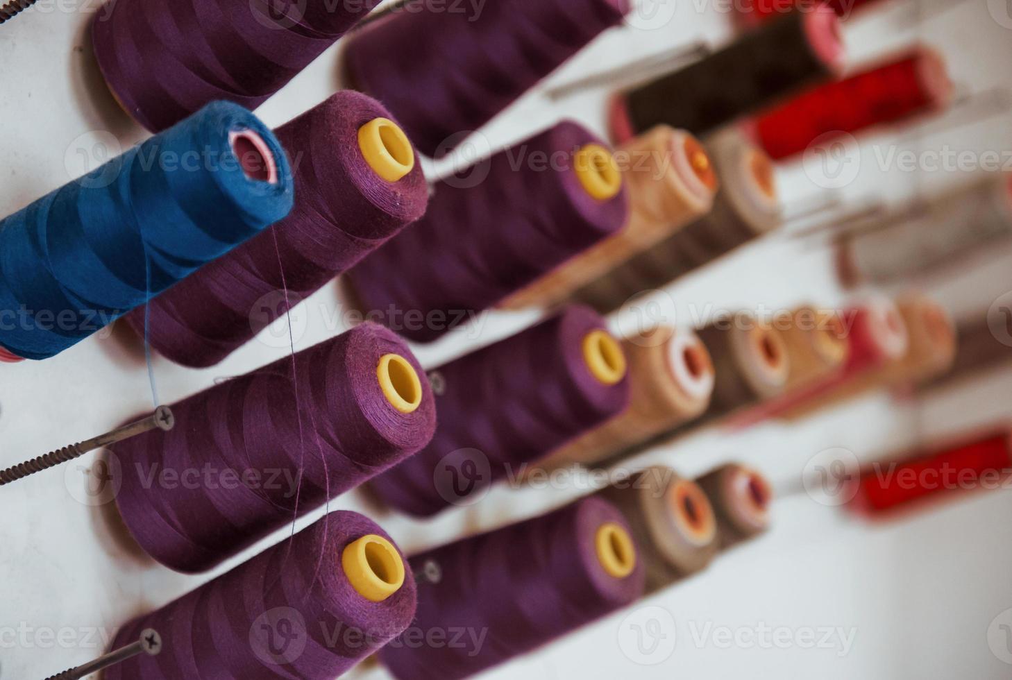 Close up detailed view of colorful spools of thread on bolts photo