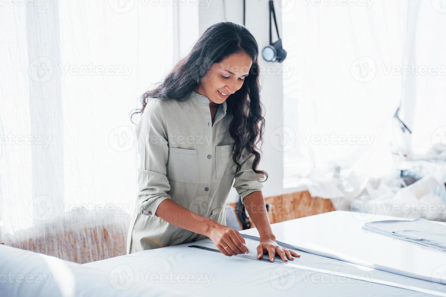 Beautiful female worker is in the sewing factory at daytime photo