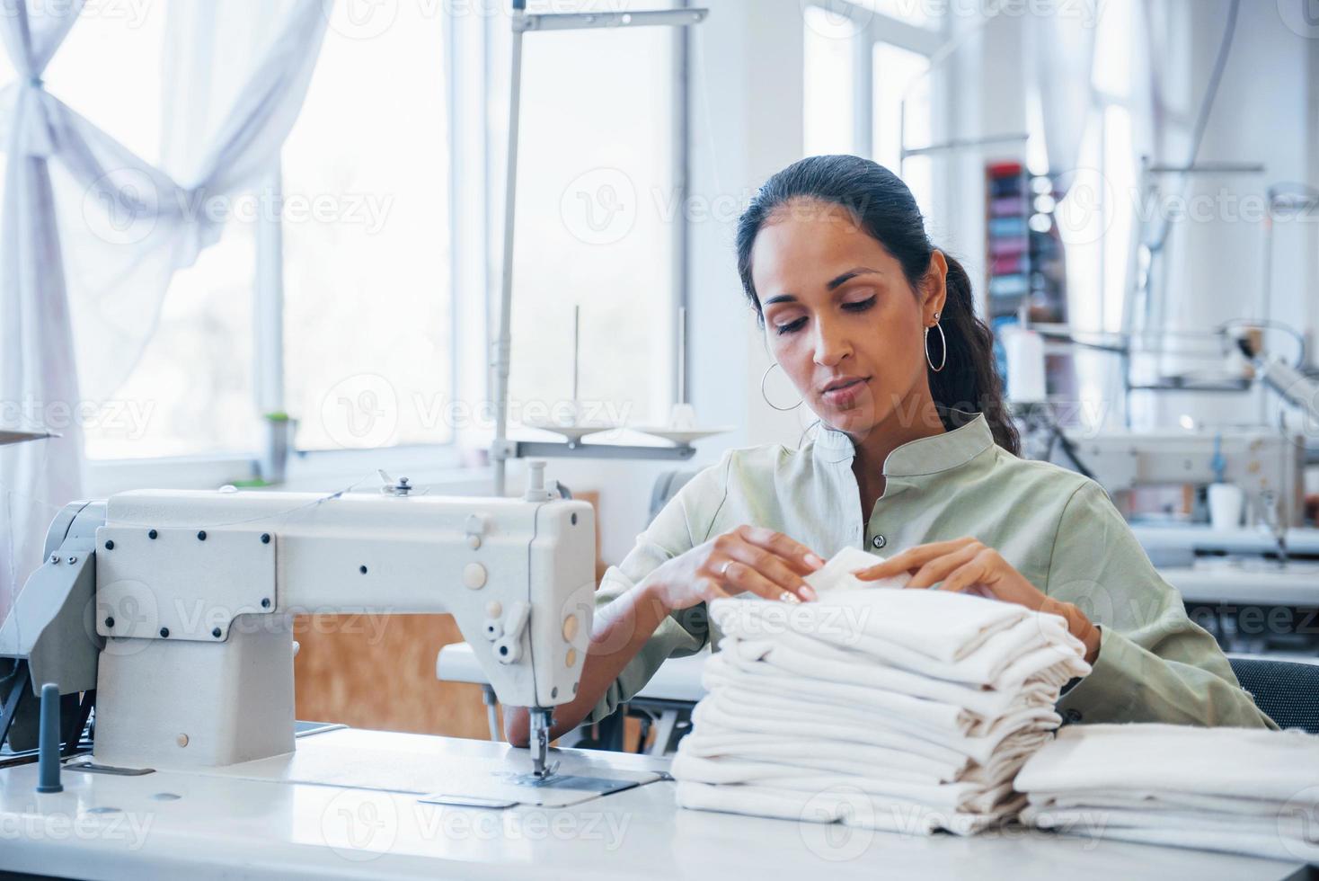 Dressmaker woman sews clothes on sewing machine in factory 15228012 Stock Photo at Vecteezy
