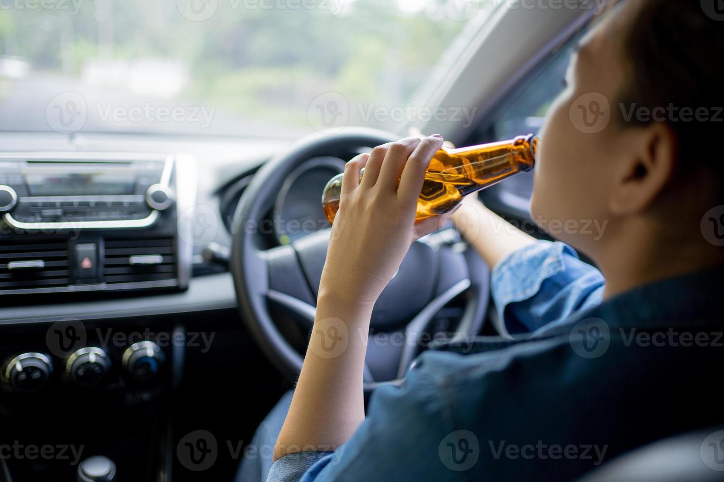 mujer joven bebiendo cerveza mientras conduce, accidente, no beba y conduzca el concepto. foto