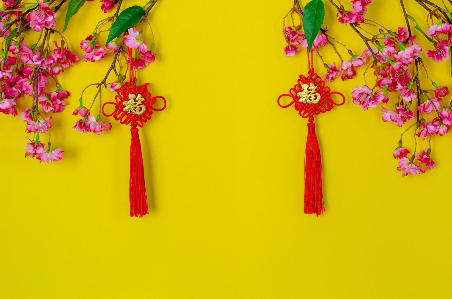 Hanging pendants for Chinese new year ornament meaning of word is wealth with Chinese blossom flowers on yellow background. photo