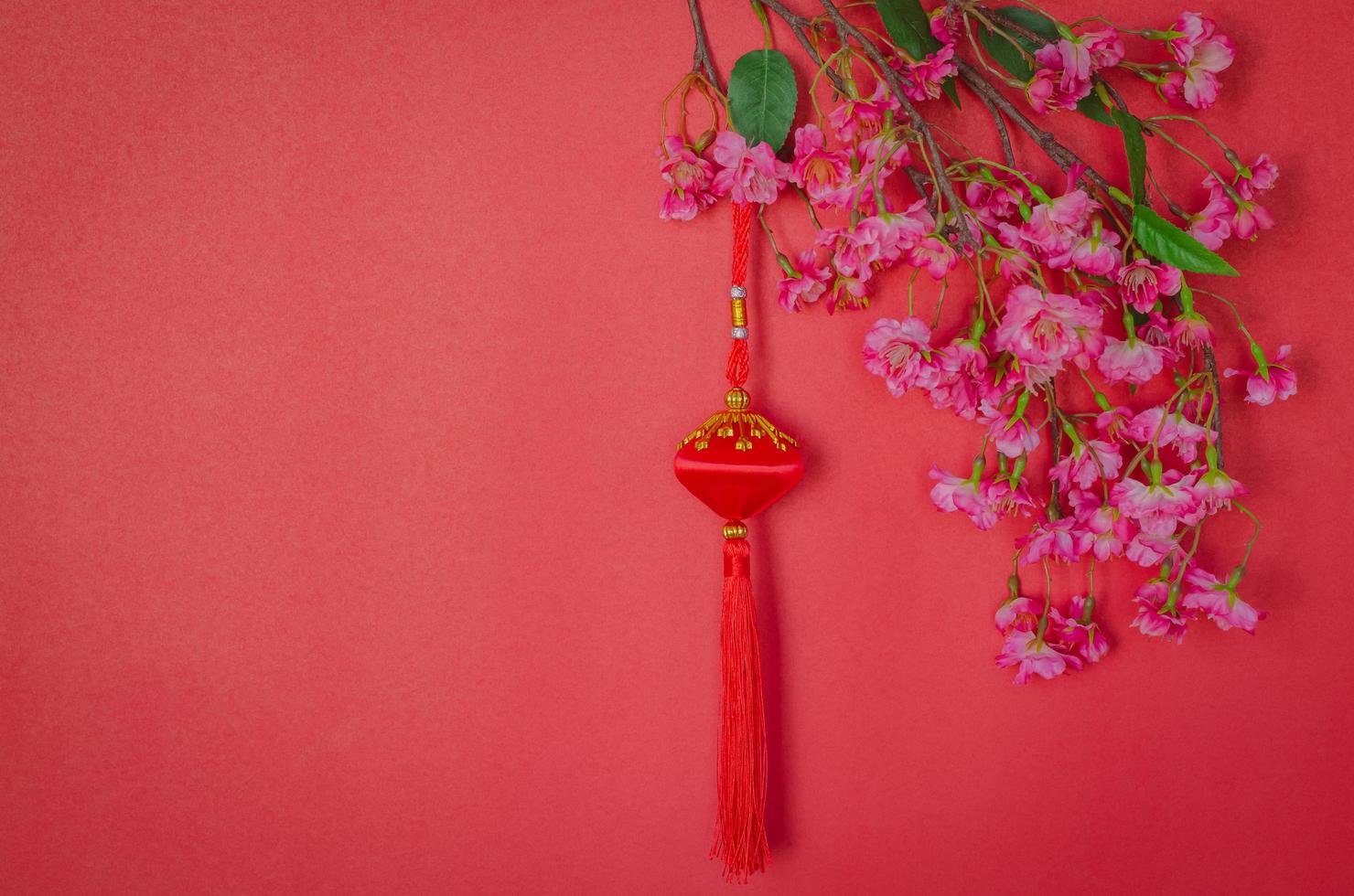 Hanging pendant for Chinese new year ornament with Chinese blossom flowers on red background. photo