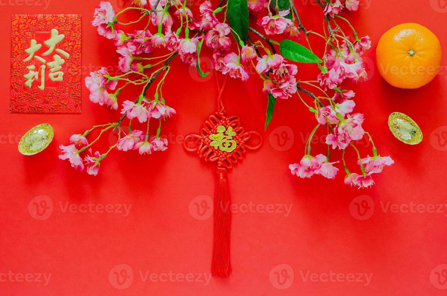 colgante colgante para el año nuevo chino palabra ornamental significa riqueza con paquete de sobre rojo o palabra ang bao significa auspicio, lingotes de oro, flores de naranja y flores chinas sobre fondo rojo. foto