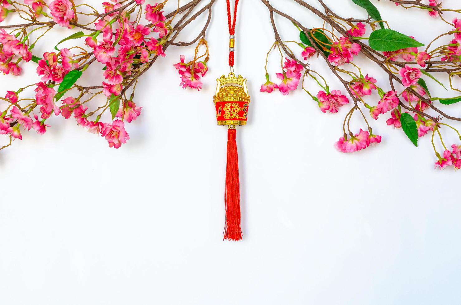 Hanging pendant for Chinese new year ornament meaning of word is wealth with Chinese blossom flowers on white background. photo
