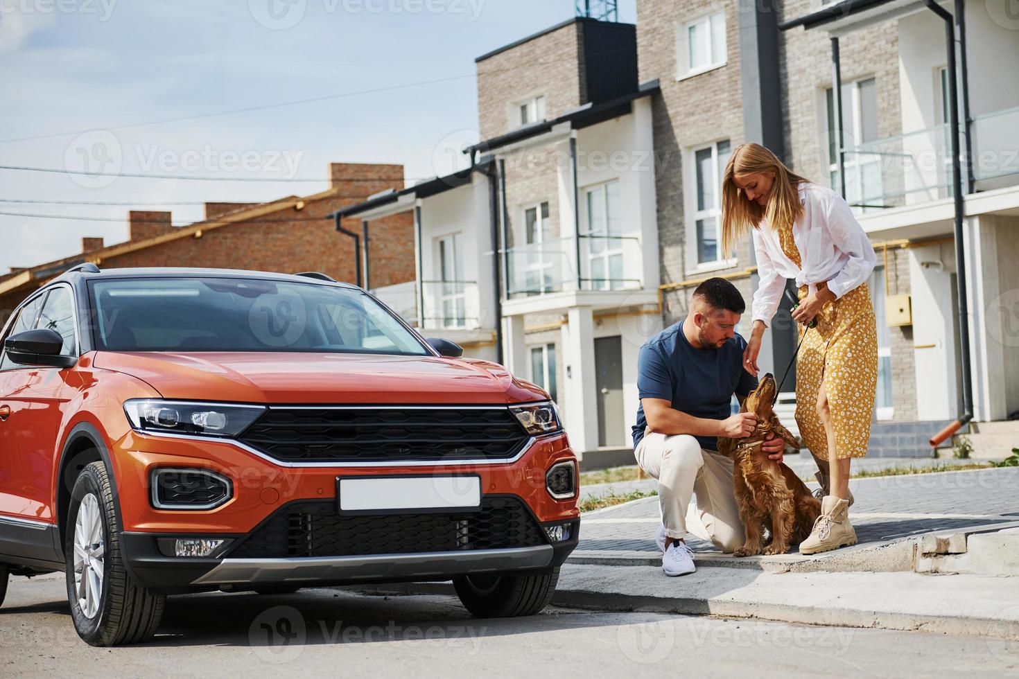 Lovely couple have a walk together with dog outdoors near the car photo