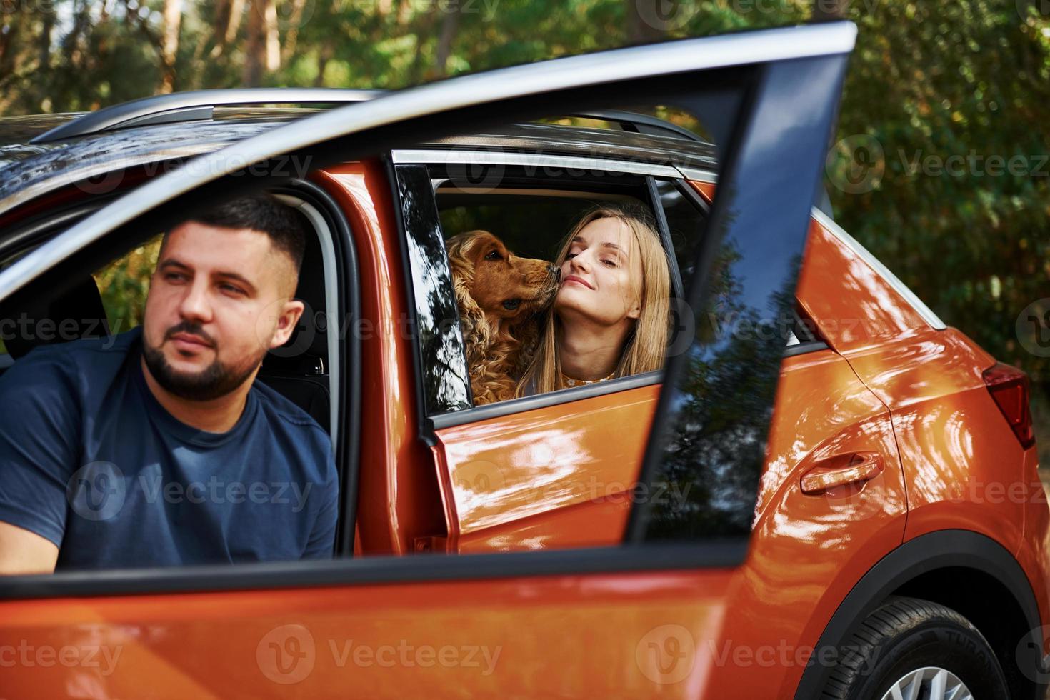 Beautiful couple have weekend time and sitting in the car that parked outdoors in the forest photo