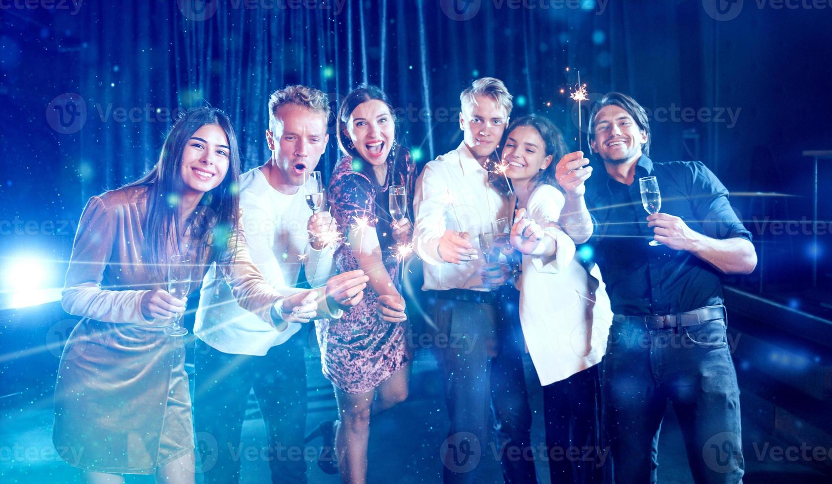 Group of cheerful young people have party and celebrating new year indoors photo