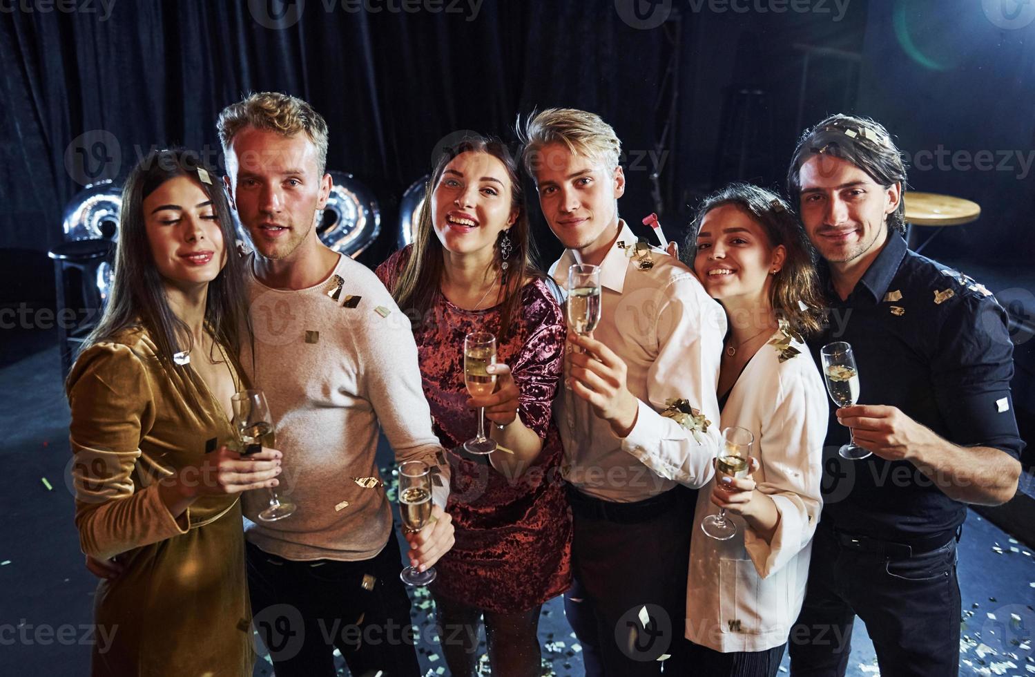 Cheerful group of people with drinks in hands celebrating new 2021 year photo