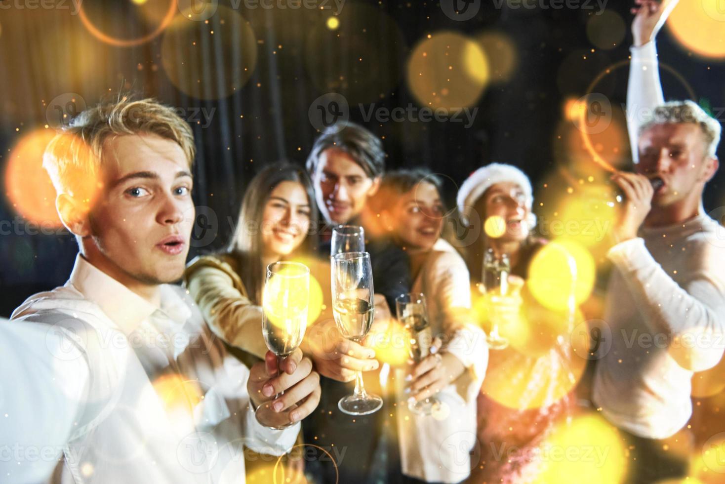 Group of cheerful young people have party and celebrating new year indoors photo