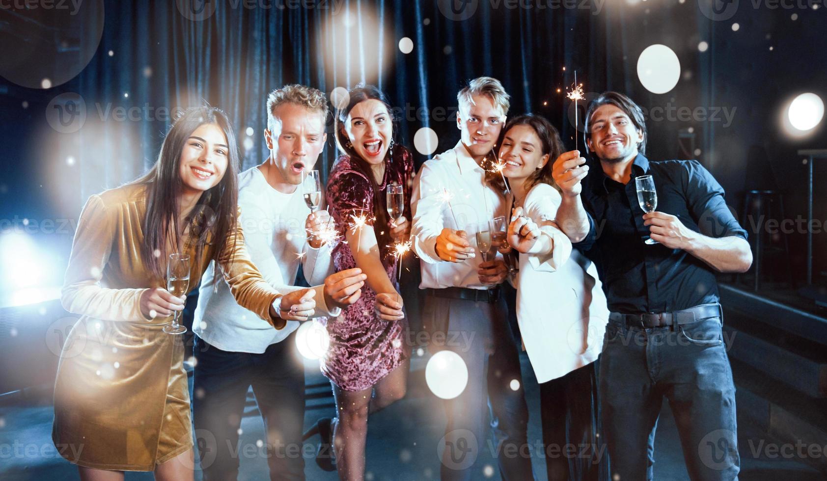 Group of cheerful young people have party and celebrating new year indoors photo