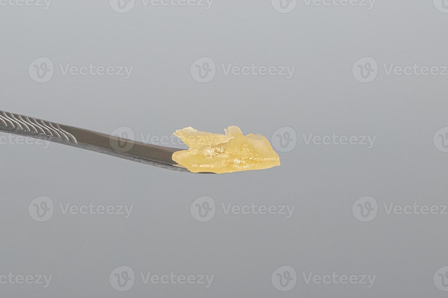 cannabis resin wax and dab tool for smoking close up on gray background photo