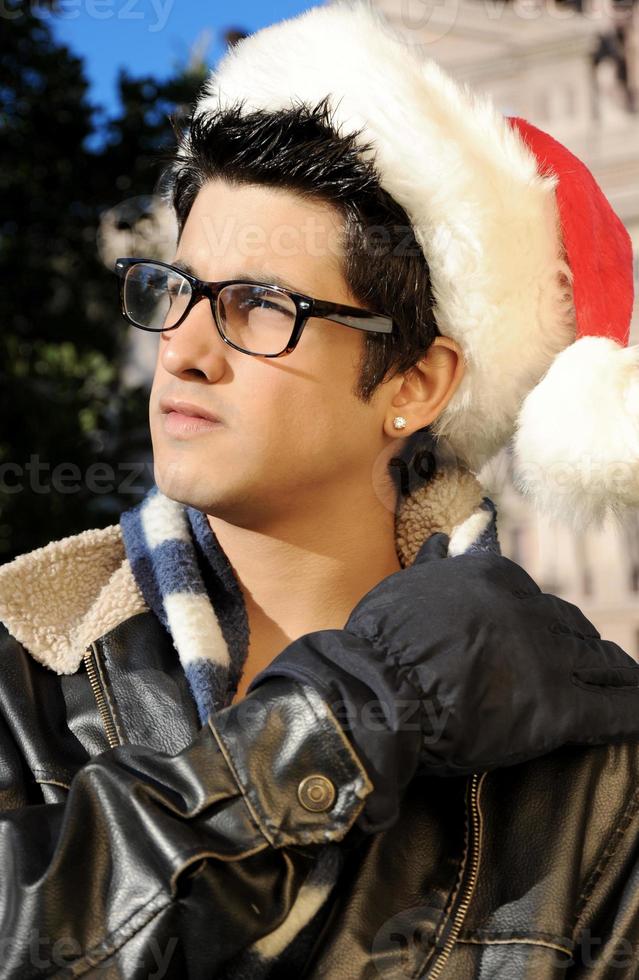 College Student dresses as a Smart Santa with his reading glasses looking very smart and sexy.. photo