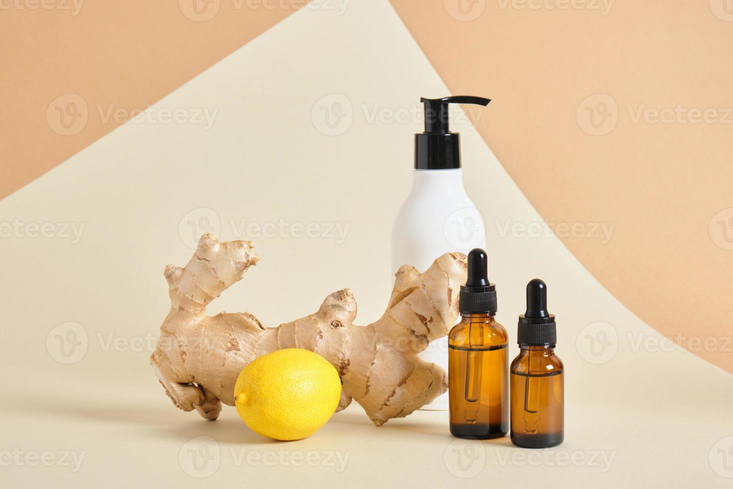 lemon, cream bottle with dispenser, amber glass dropper bottles and ginger root on beige background copy space photo
