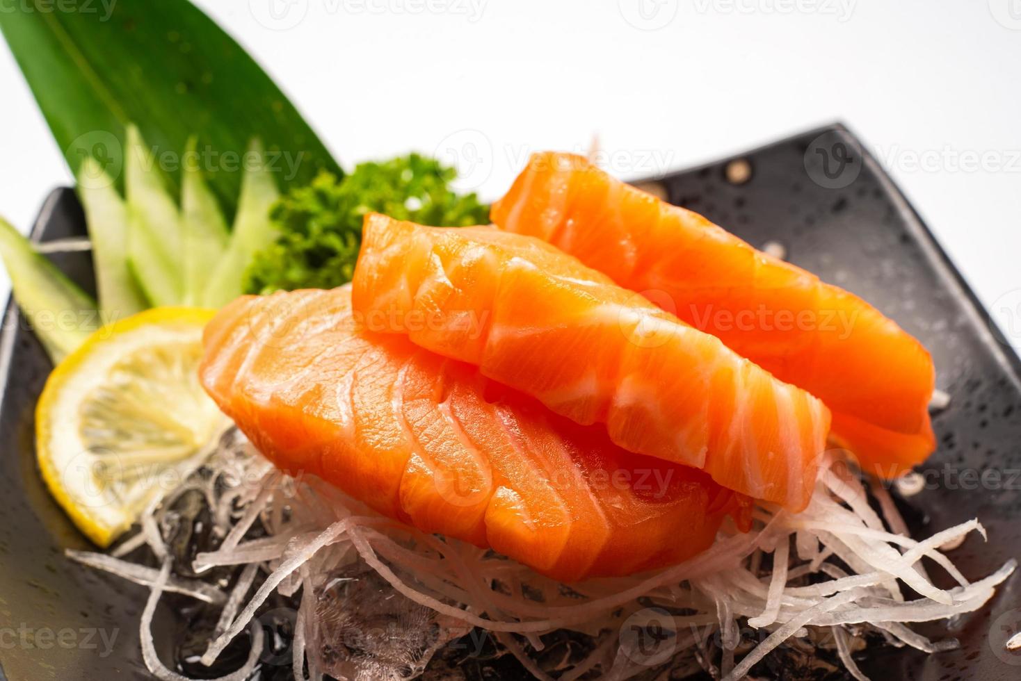 sashimi, salmón, palillos de comida japonesa y wasabi en la mesa blanca foto