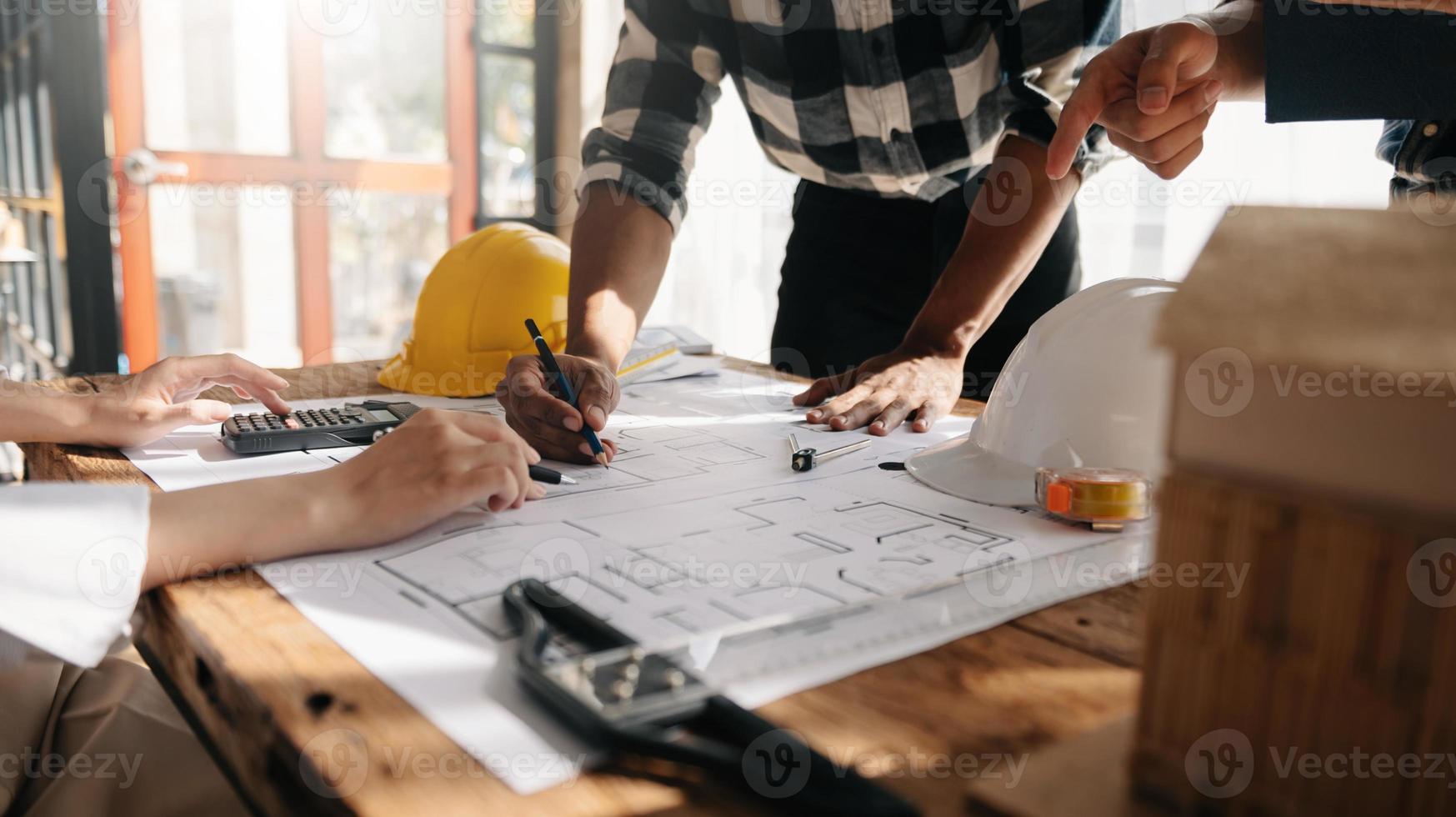 wo colleagues discussing data working and tablet, laptop with on on architectural project at construction site at desk photo