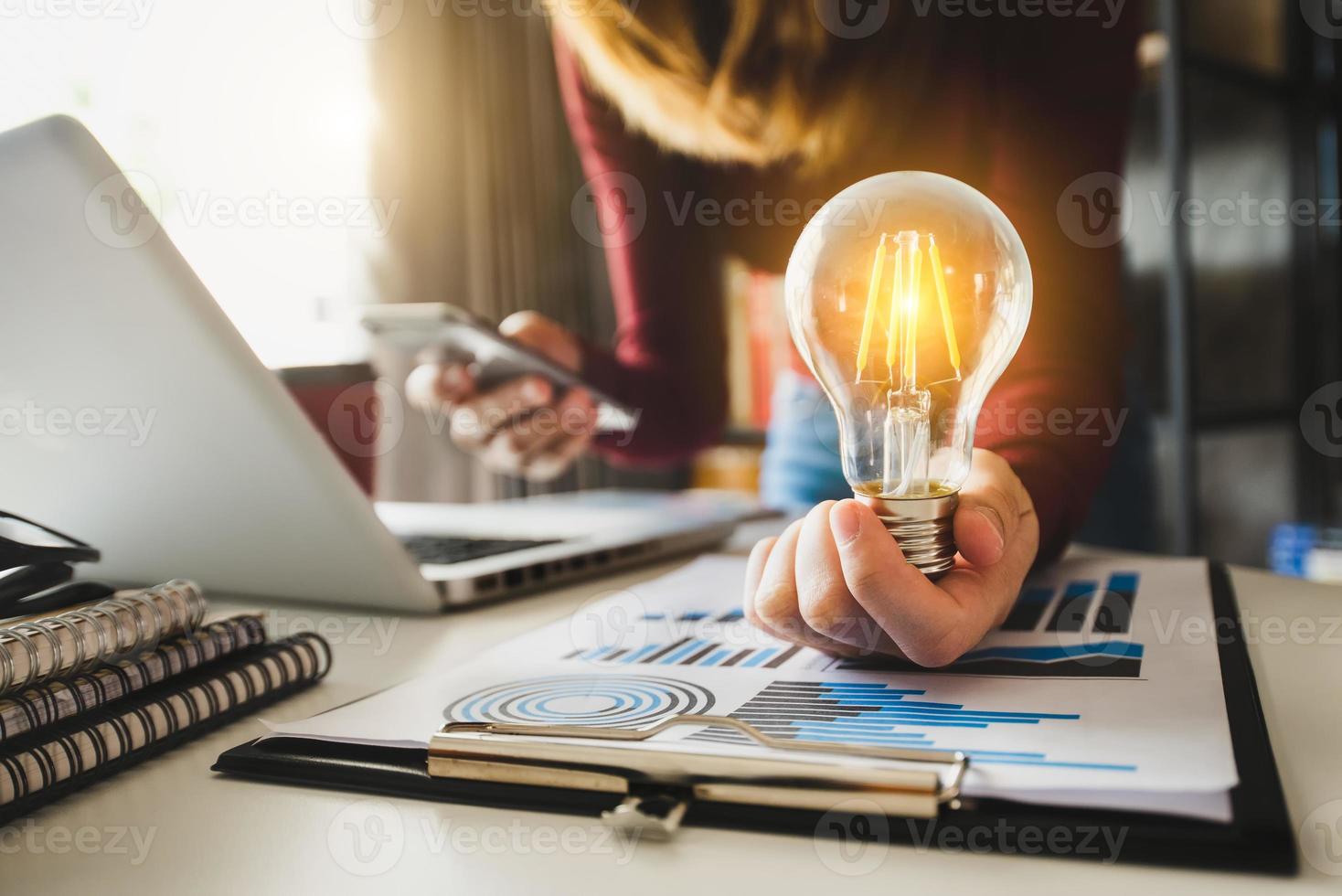 business woman using smartphone, tablet and holding light bulb, photo