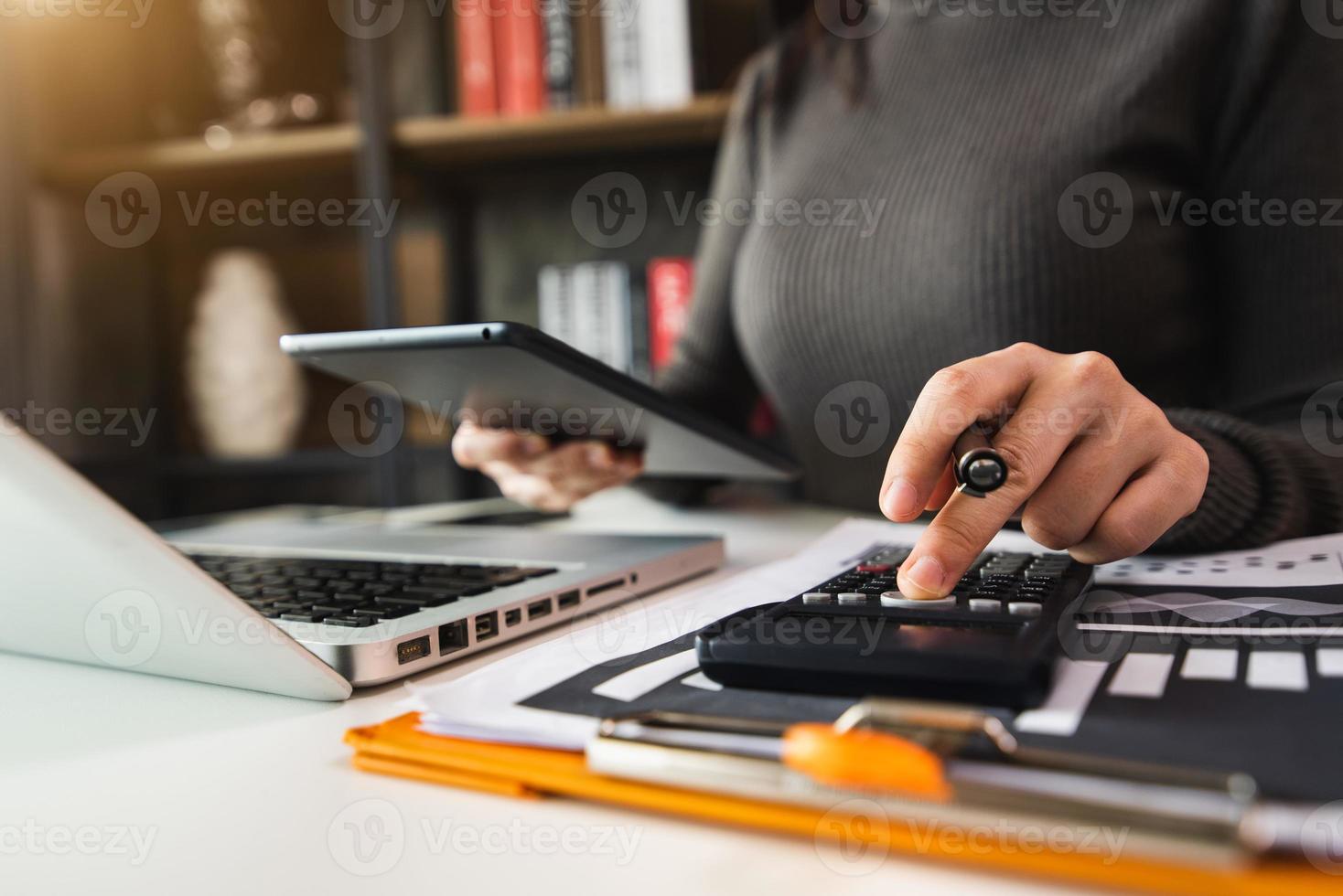 business working on desk office with using a calculator to calculate the numbers, finance accounting concept photo