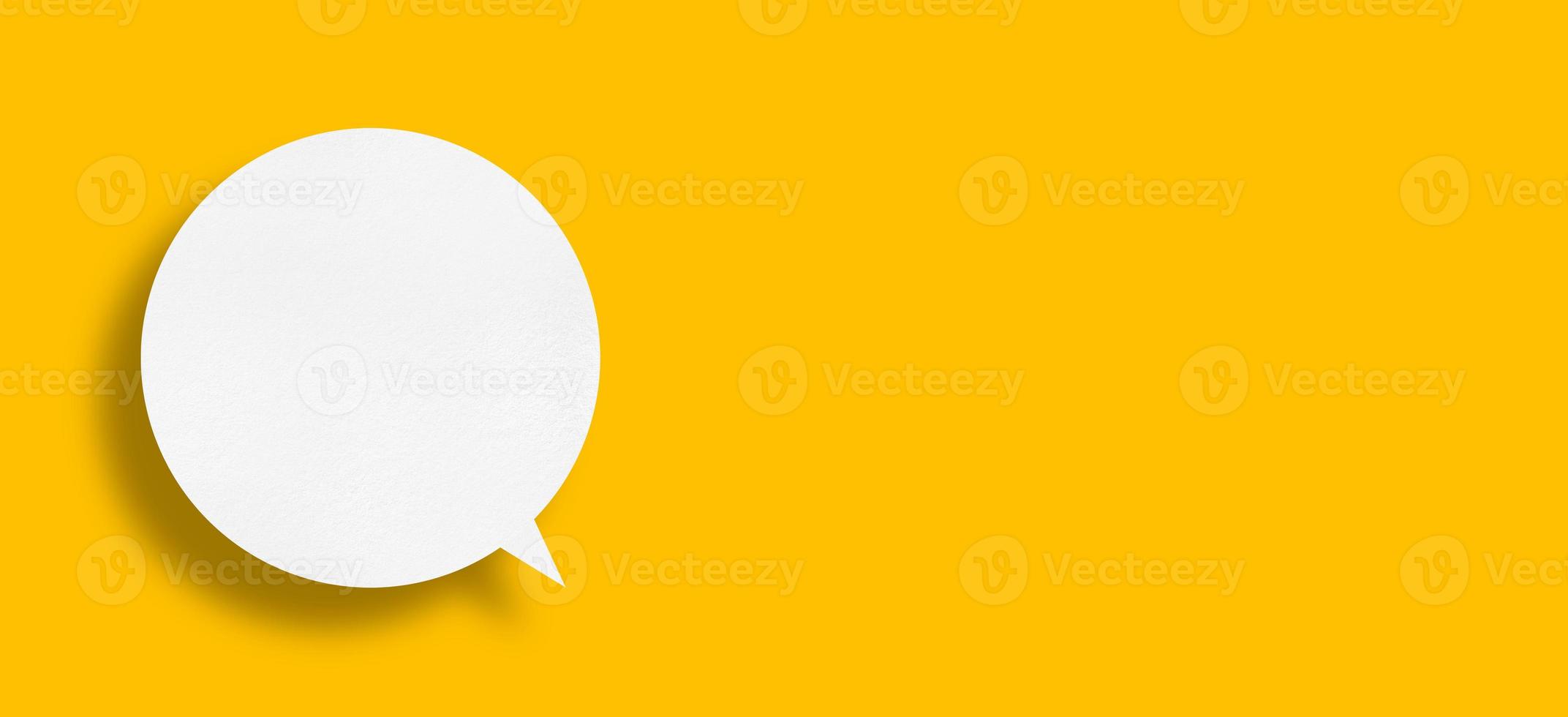 White paper in speech bubble shape set against yellow background. photo