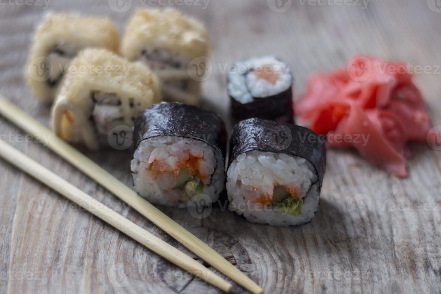 primer plano de rollos japoneses de aguacate y salmón sobre un fondo de madera foto