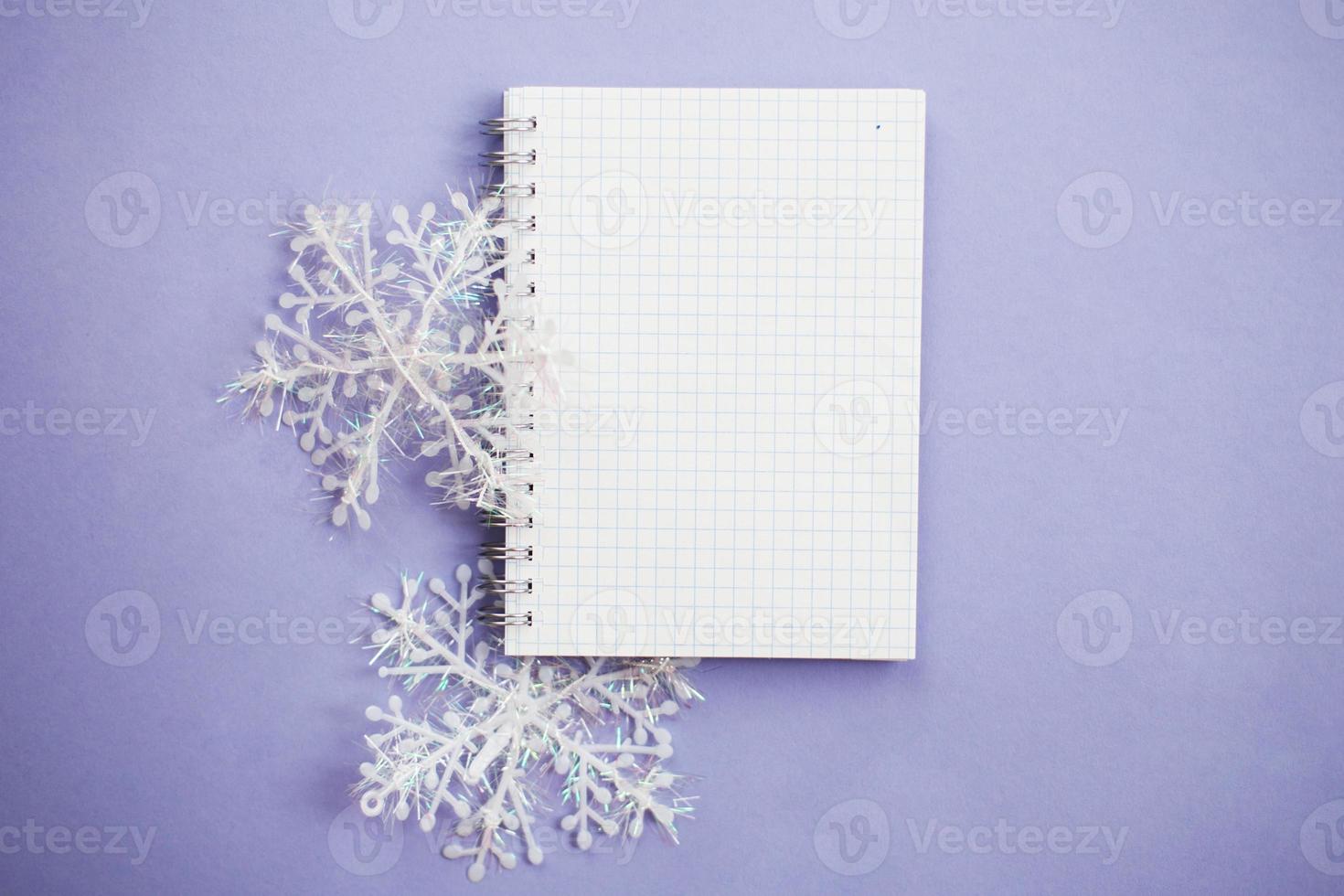 empty notebook for writing wish list with snowflake on a purple background photo