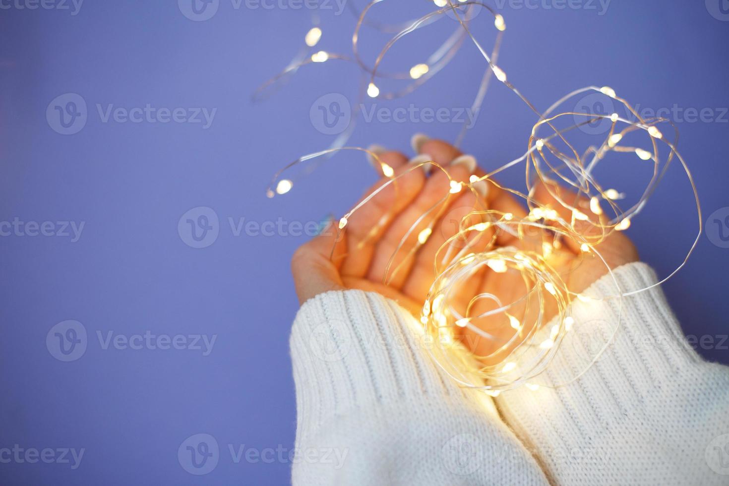Cozy nails with winter manicure with snowflakes and lights on purple background photo