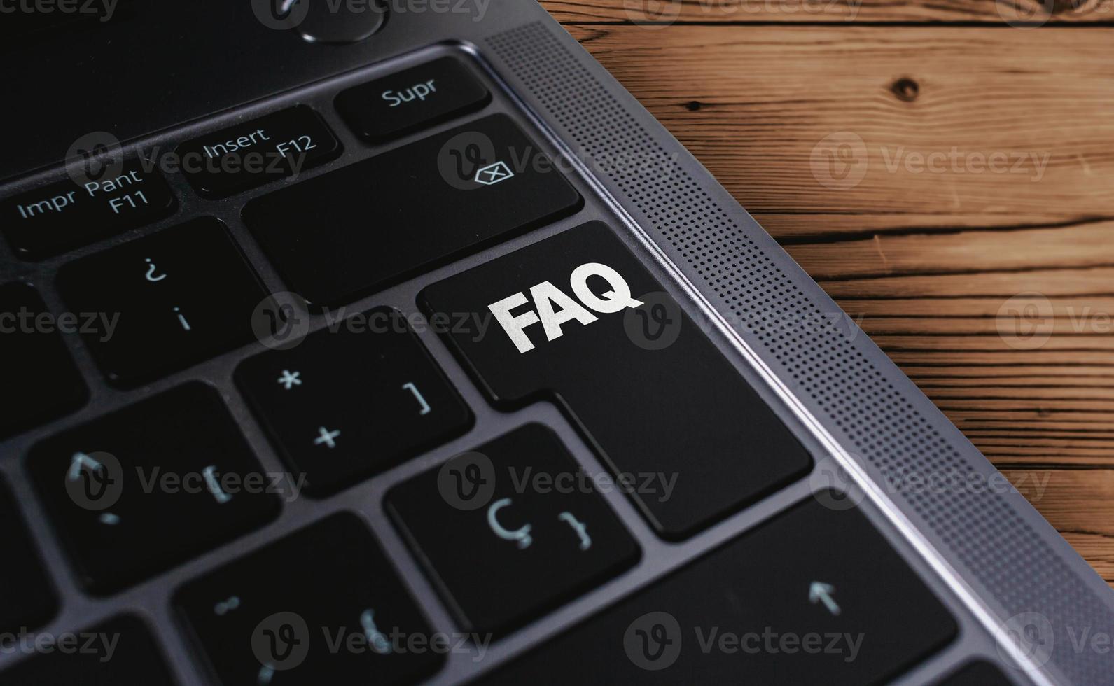 Laptop keyboard with FAQ word on button. Business support concept. Frequently asked questions symbol. photo