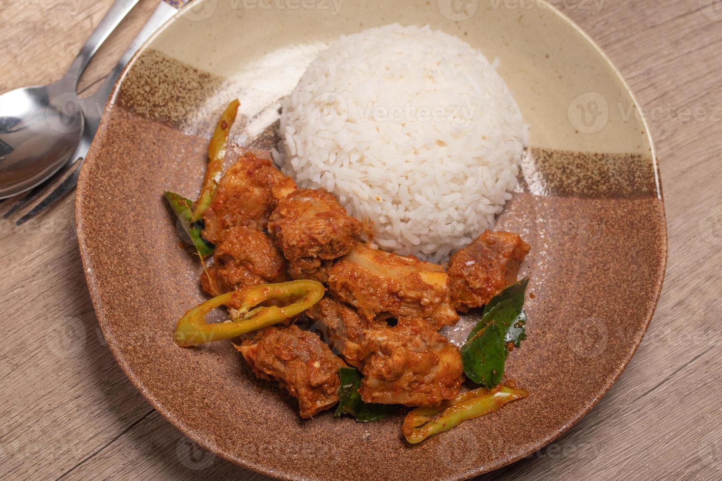 Stir-fried pork ribs with curry paste and steamed rice photo