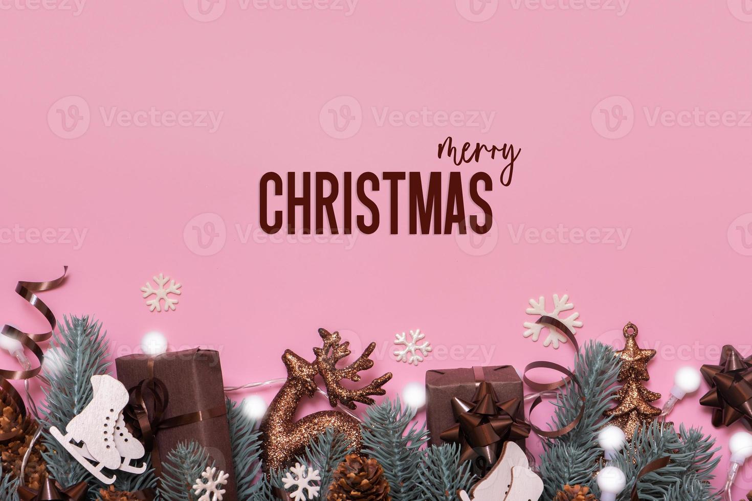 Merry Christmas text. Greeting card with winter holidays decoration top view, flat lay on pink background photo