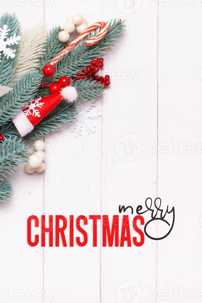 Merry Christmas text with Xmas composition made from pine tree, snowflakes and festive decorations top view photo