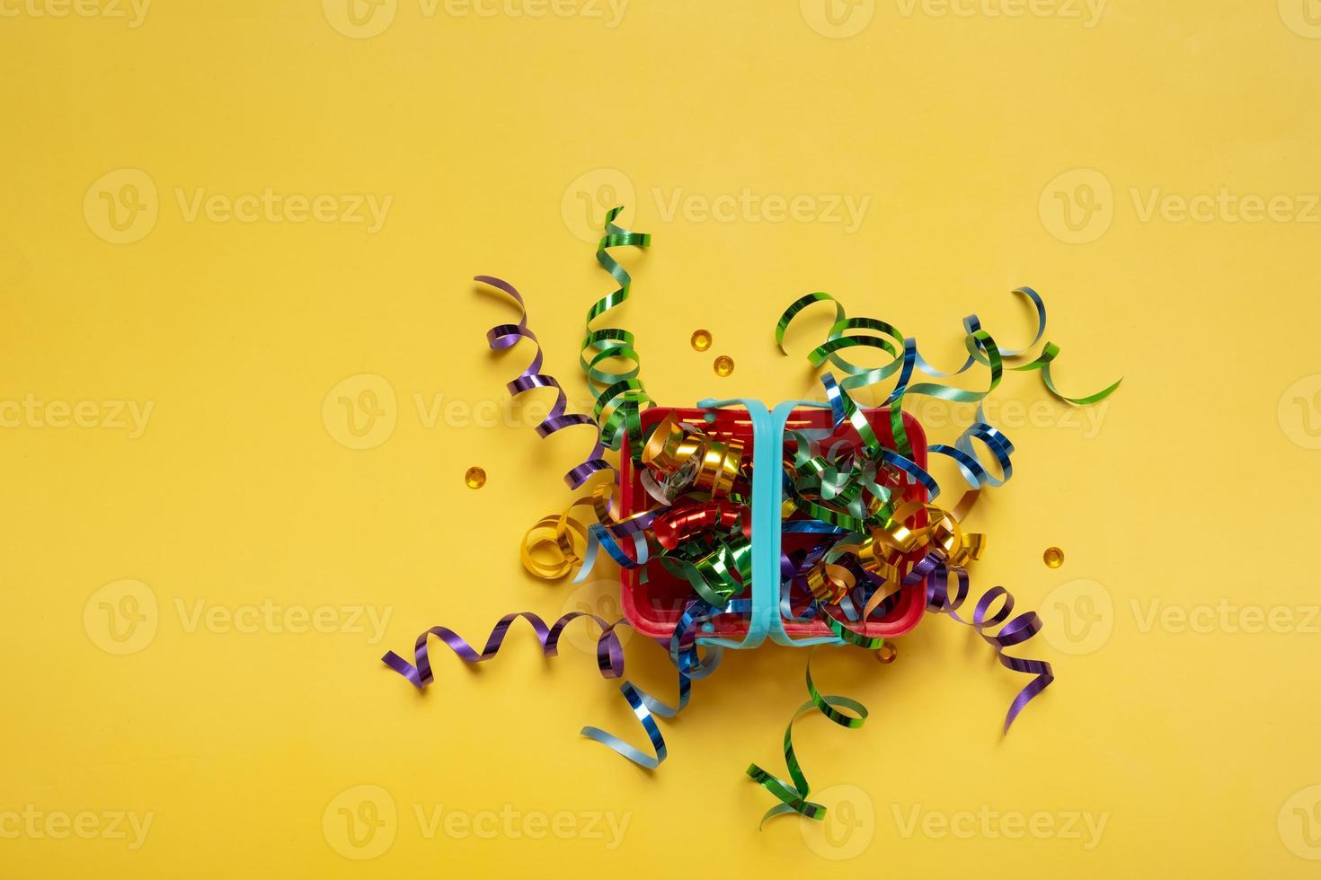 Shopping basket with spirals of colorful tinsel  on a colored background. Copy space photo