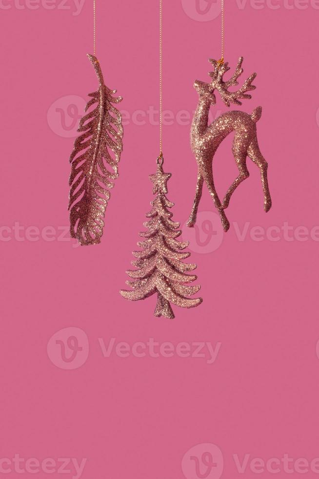 Christmas New Year banner with XMAS tree, deer and feather glitter toys on brown background with copy space photo