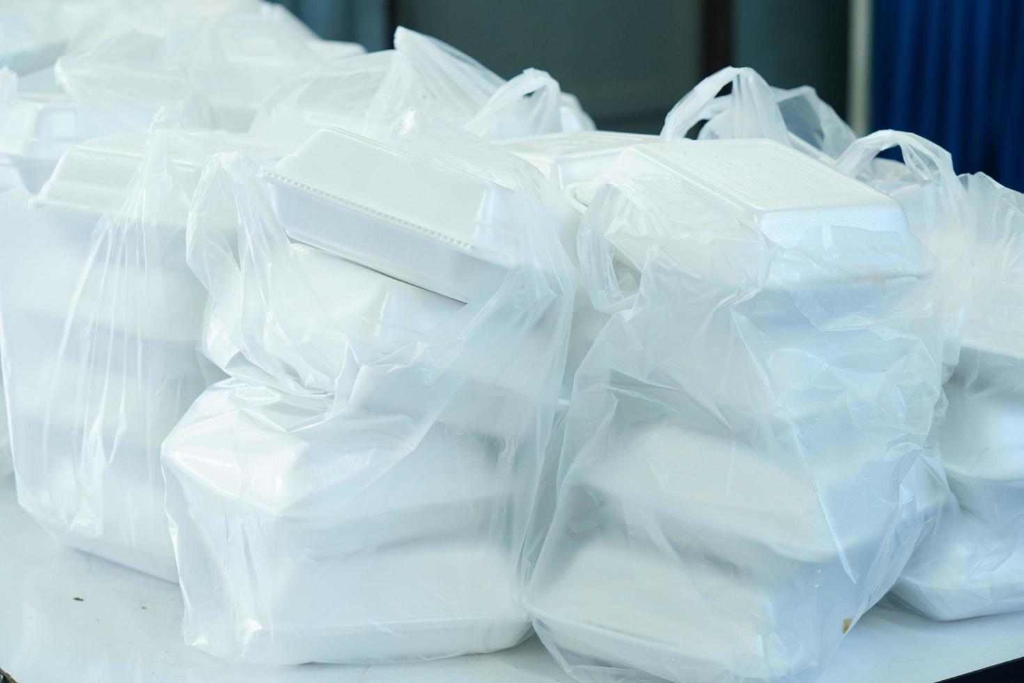 White Styrofoam boxes containing food stacked in plastic bags. photo