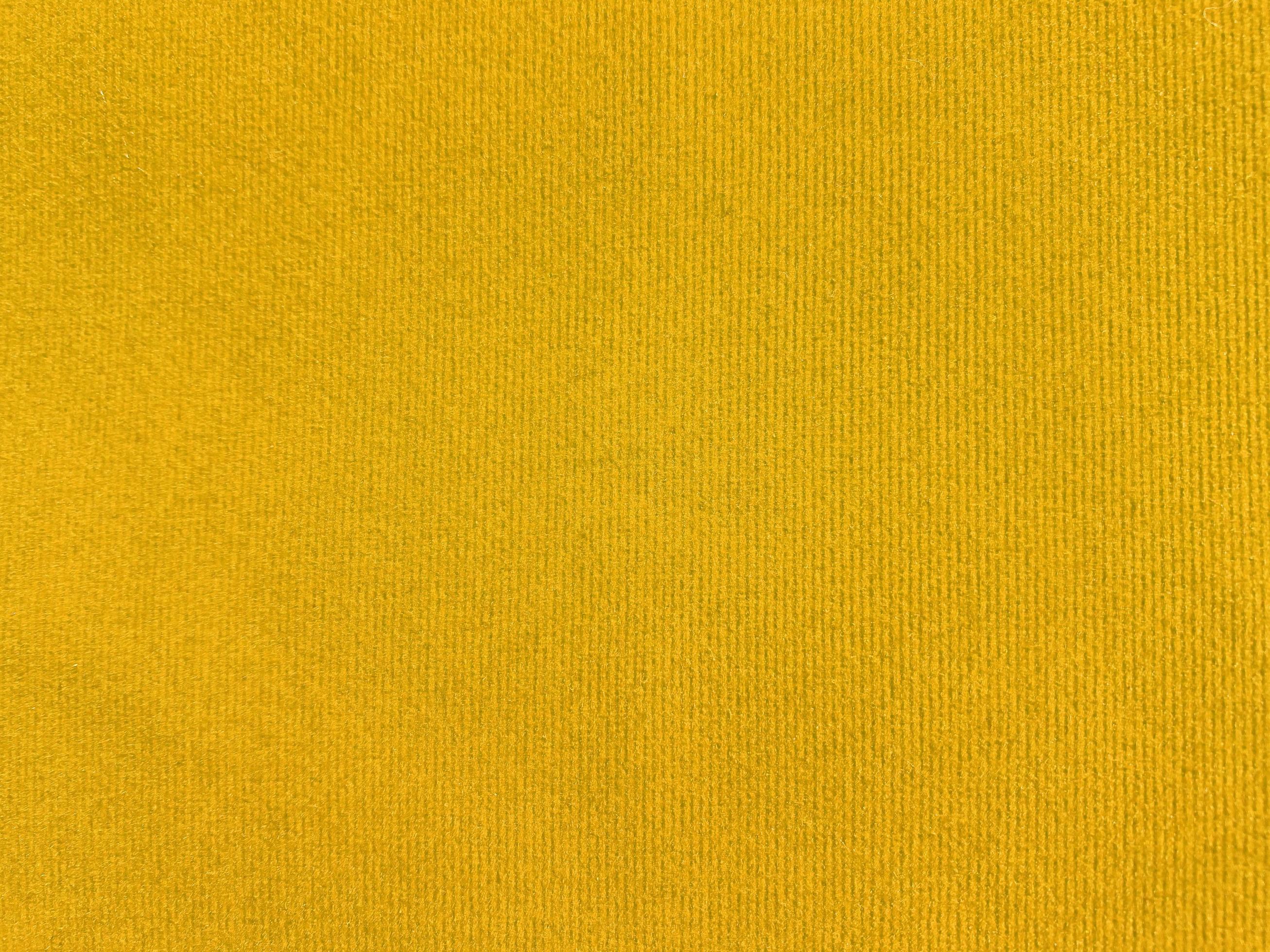 Yellow velvet fabric texture used as background. Empty yellow fabric