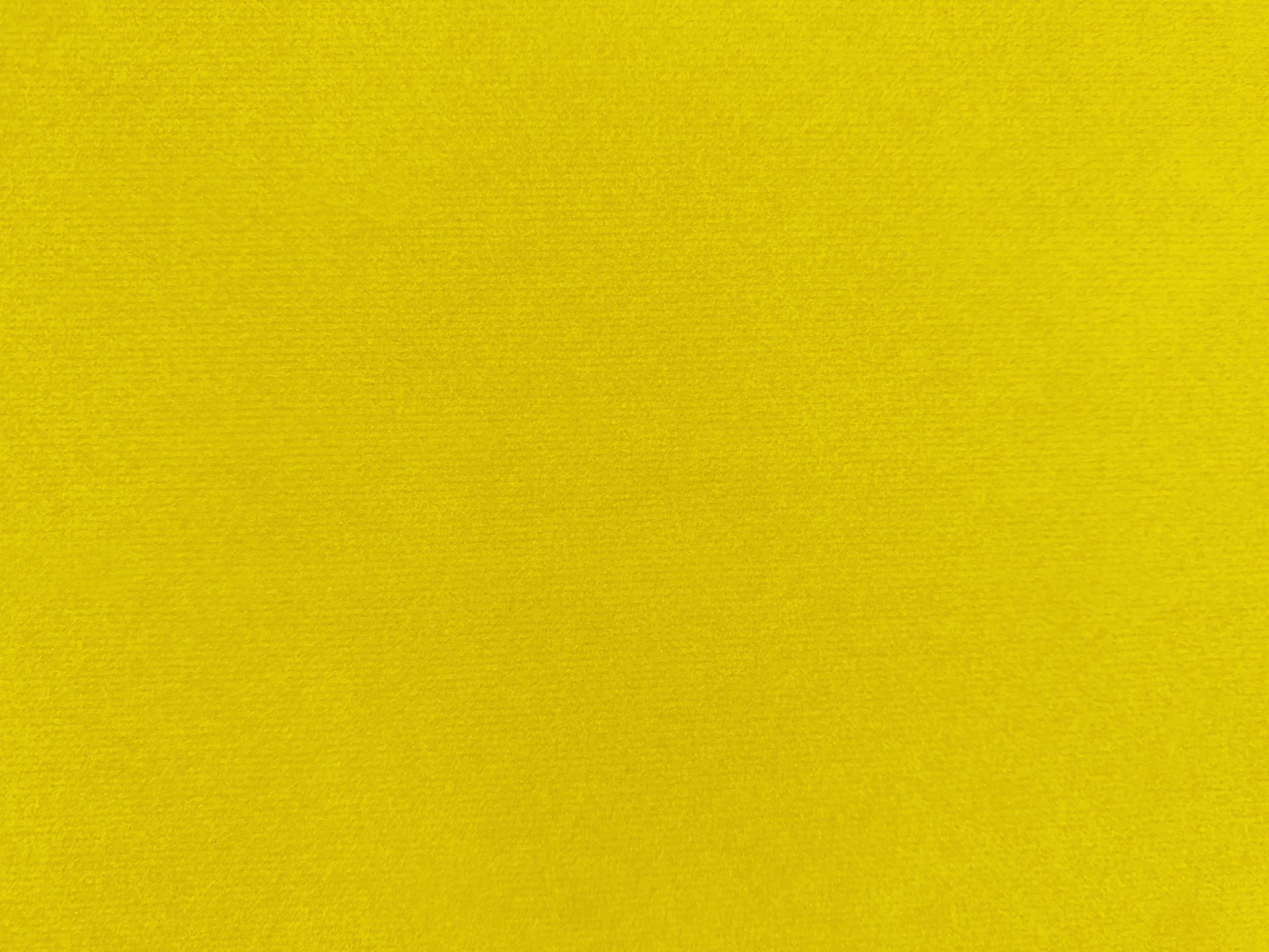 Yellow velvet fabric texture used as background. Empty yellow fabric