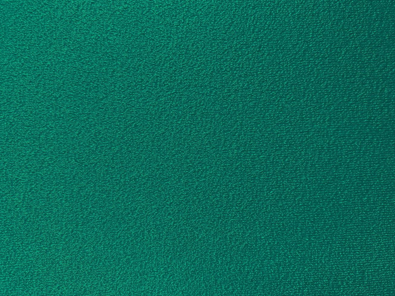 Dark green cotton fabric texture used as background. Empty green fabric