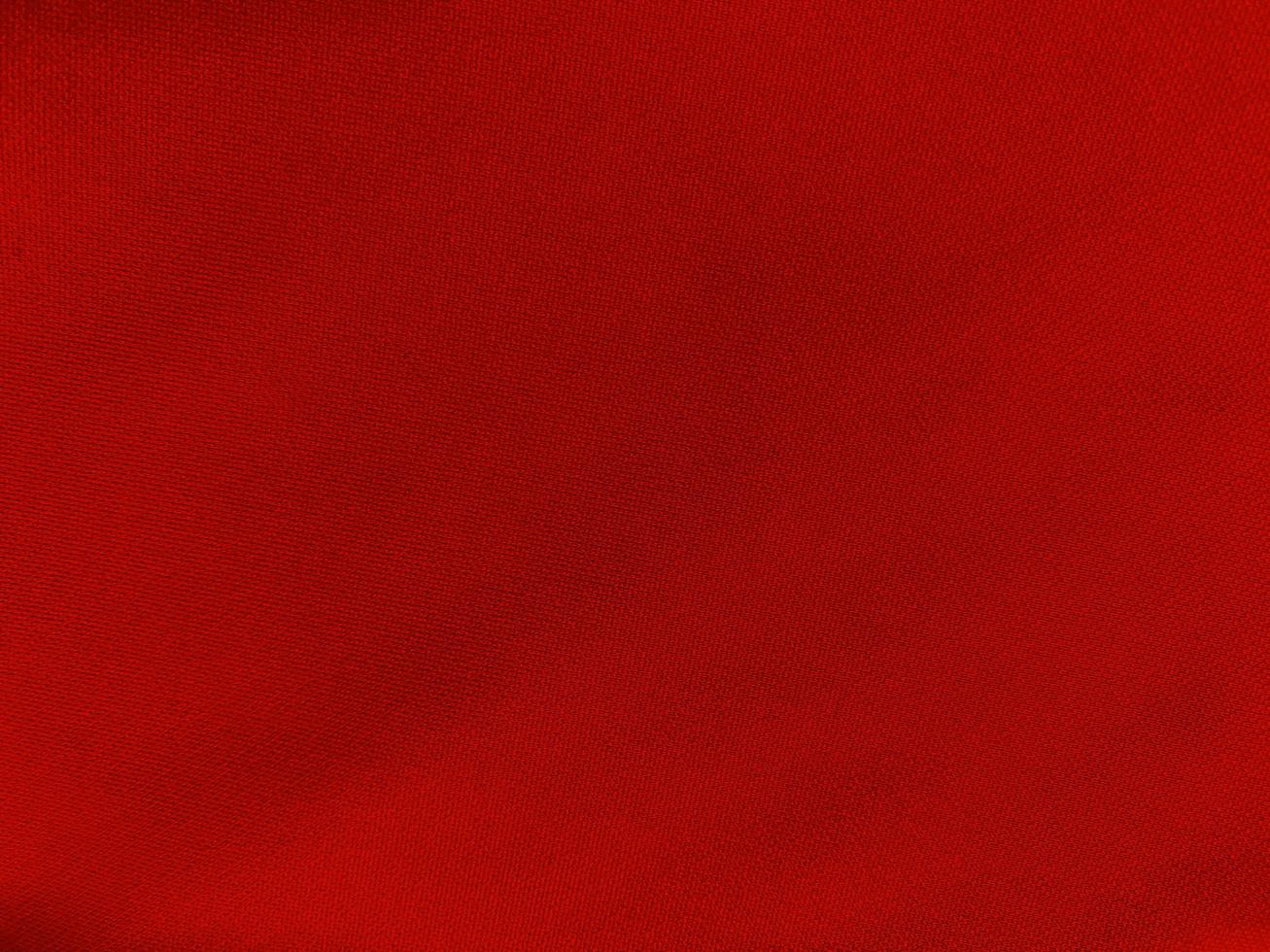 textura de tela de algodón rojo utilizada como fondo. fondo de tela roja vacía de material textil suave y liso. hay espacio para el texto.. foto