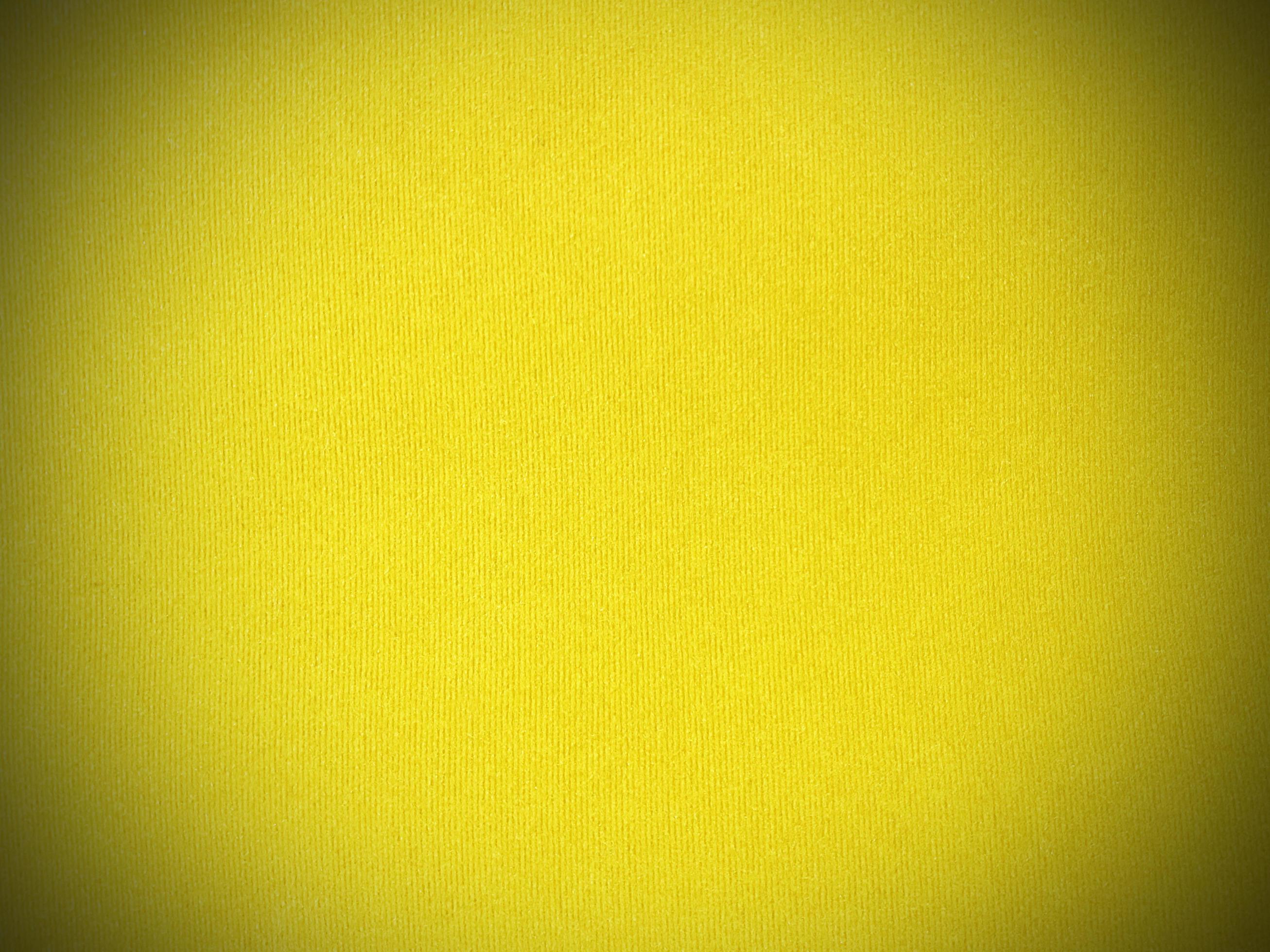 Pastel yellow velvet fabric texture used as background. Empty yellow