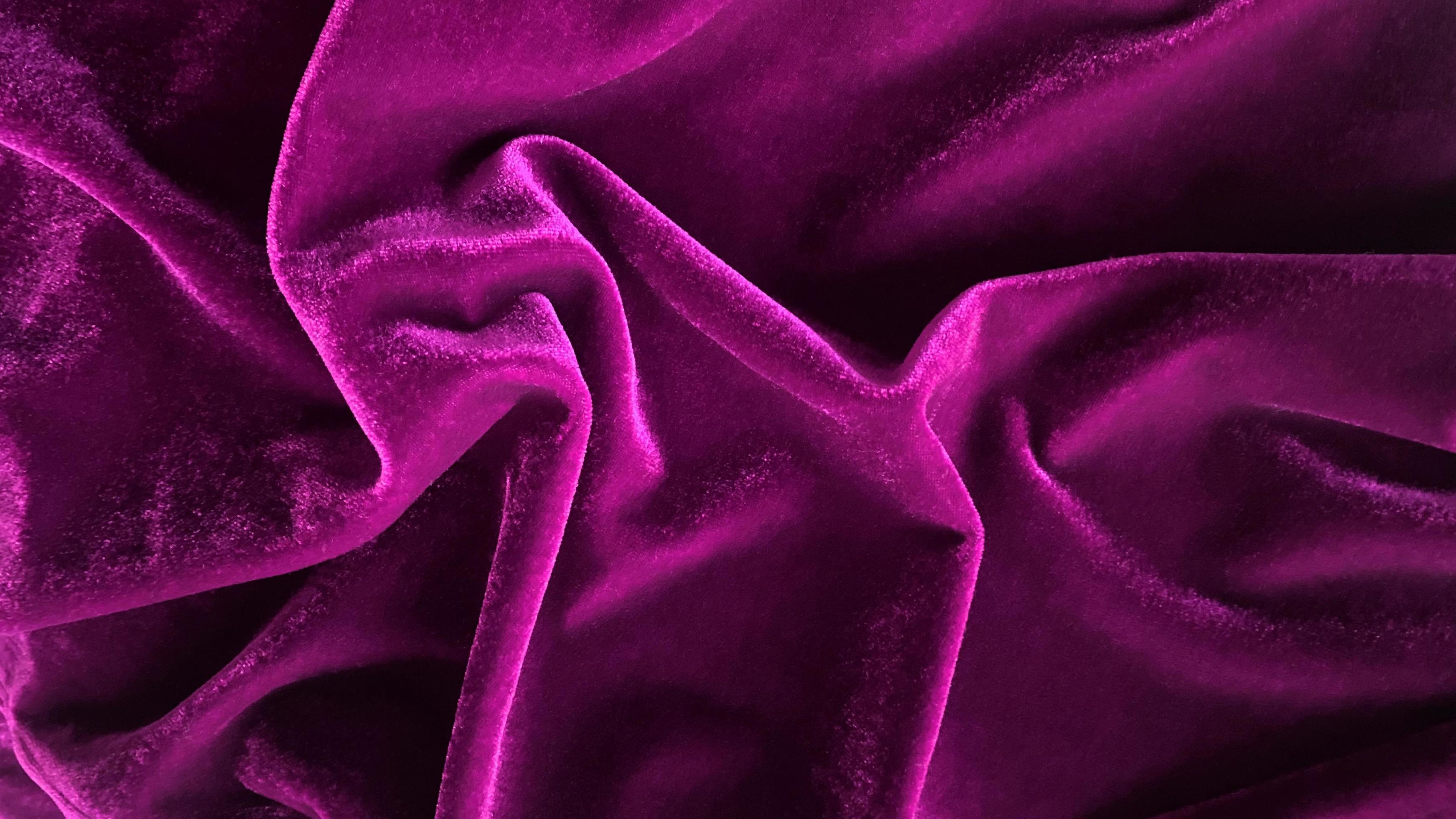 Magenta velvet fabric texture used as background. Empty magenta fabric